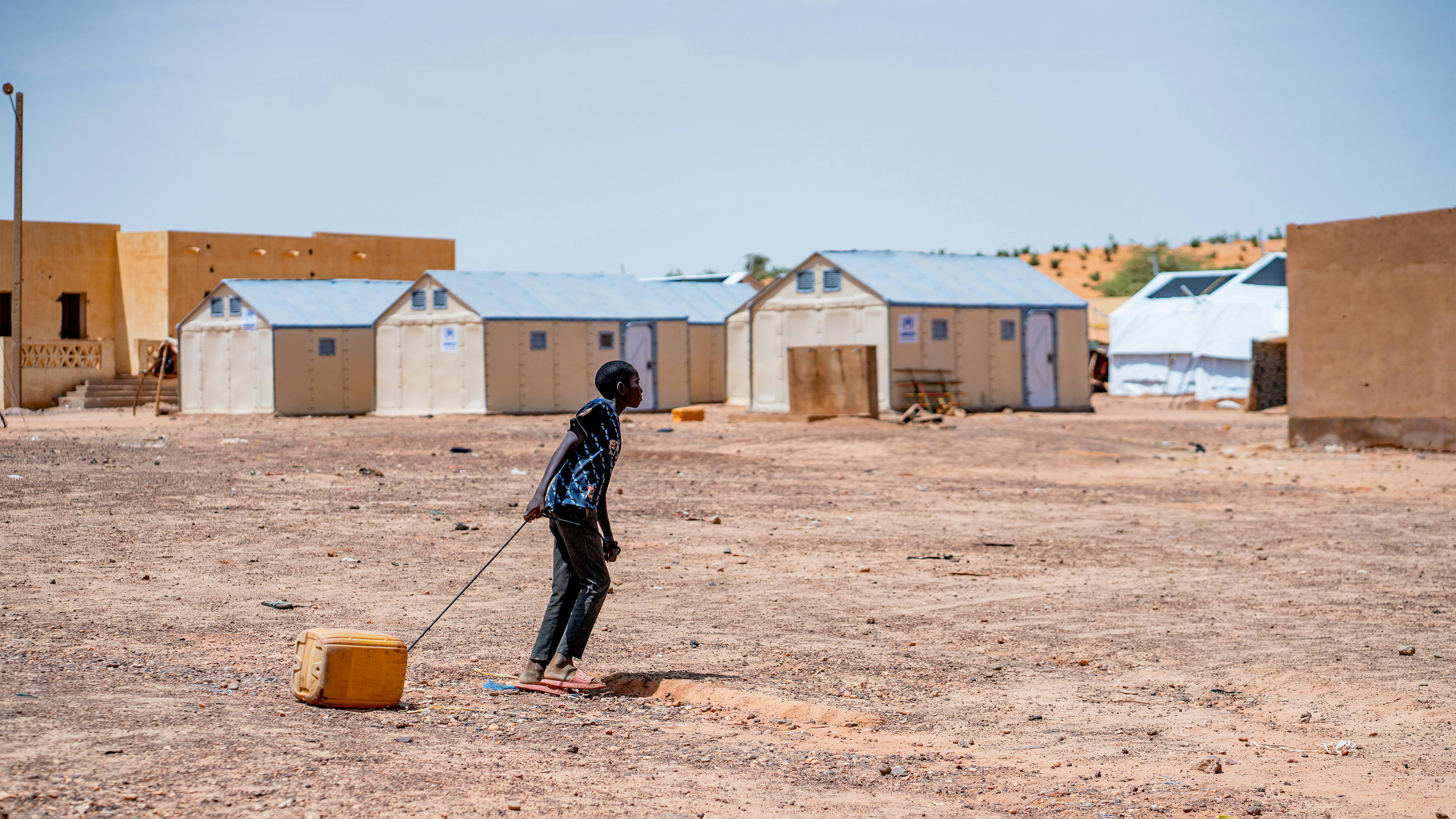 Mali - un bambino trascina una tanica d'acqua nel campo per rifugiati