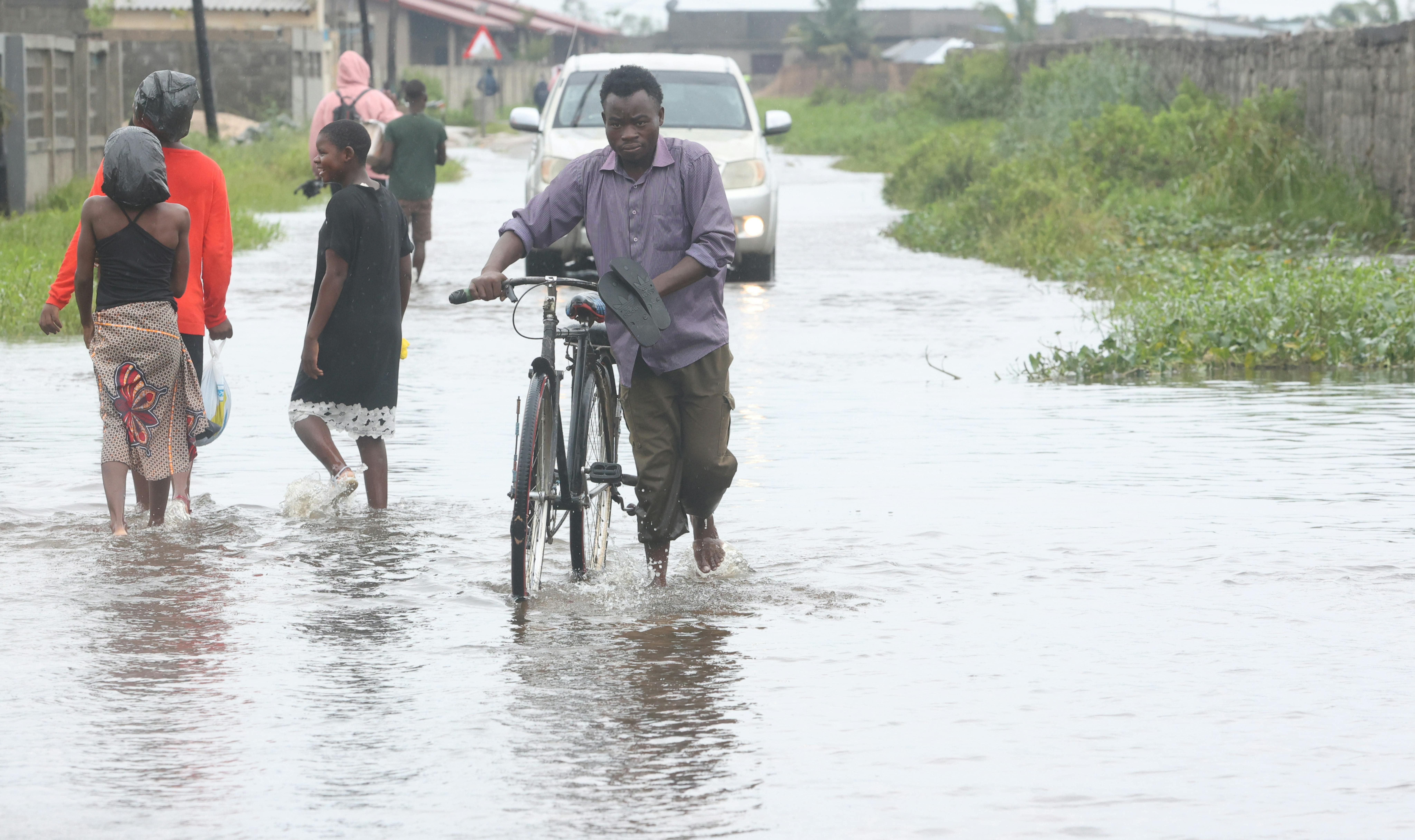 Mozambico - Un uomo cammina su una strada allagata con la sua bicicletta dopo il passaggio del ciclone Freddy...