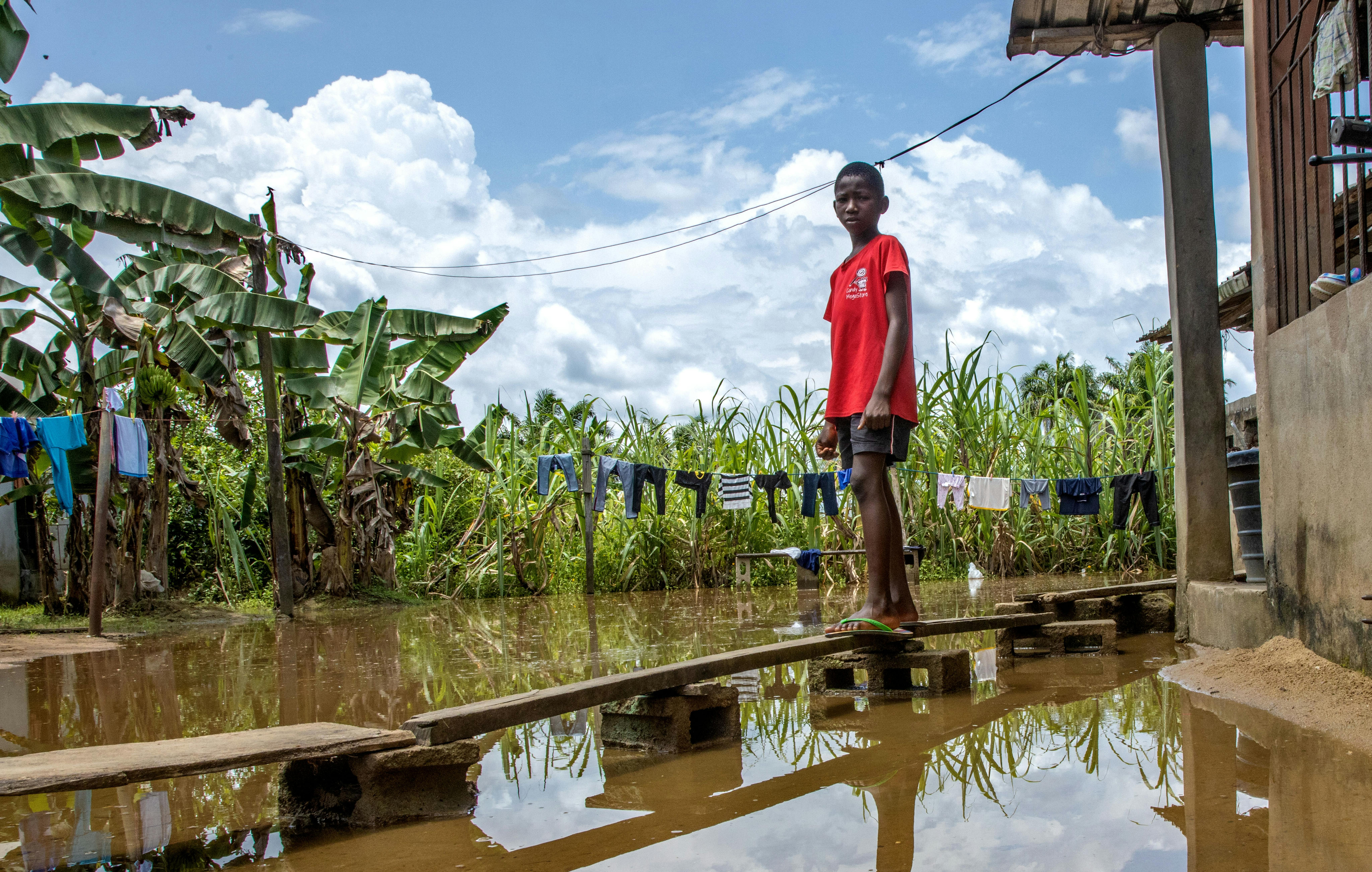 Peretimfa Germania 11 anni, è in piedi sulla passerella di legno improvvisata di fronte alla sua casa colpita dall'alluvione a Sagbama, nello stato di Bayelsa, in Nigeria.