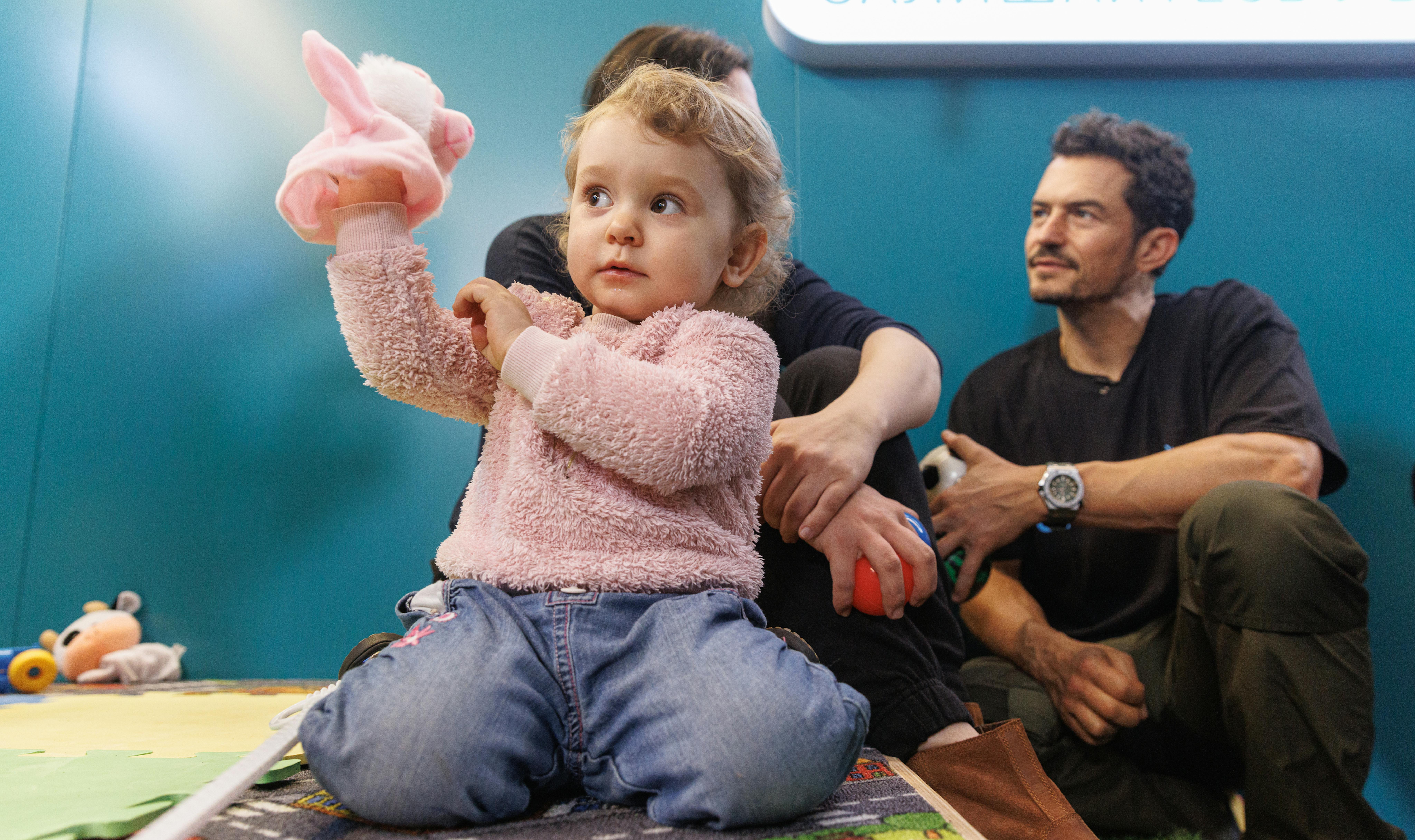 Ucraina - L'ambasciatore dell'UNICEF Orlando Bloom parla con Yulia, madre di Myroslava di 2 anni, nello Spilno Child Spot dell'UNICEF presso la stazione della metropolitana di Kiev