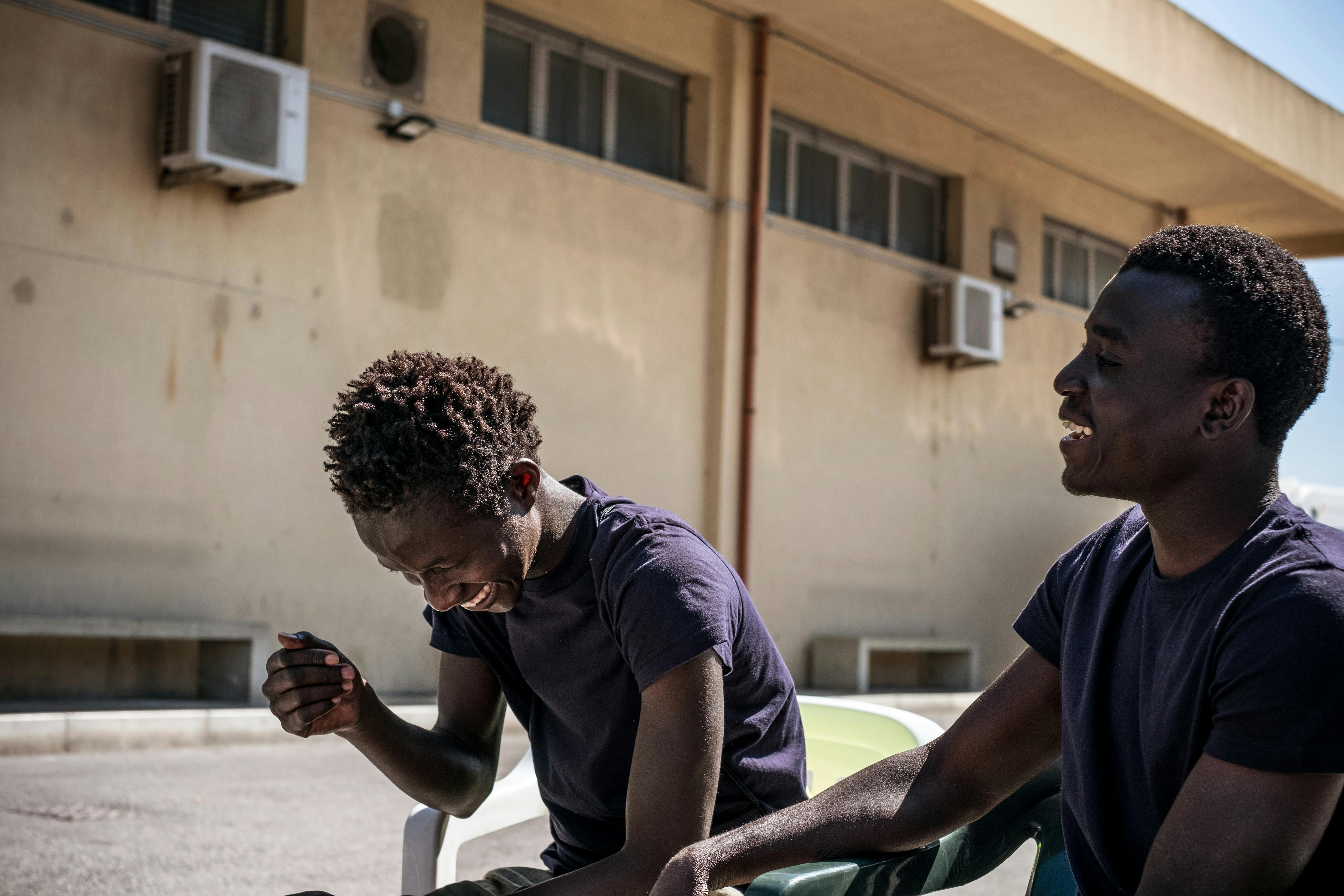 Ablie e Sanna, 17 anni, provenienti dal Gambia, ridono mentre passano il tempo in un hotspot del governo, un centro di accoglienza che funge anche da stazione di alloggio per minori non accompagnati a Pozzallo, in Sicilia, il 17 maggio 2016.