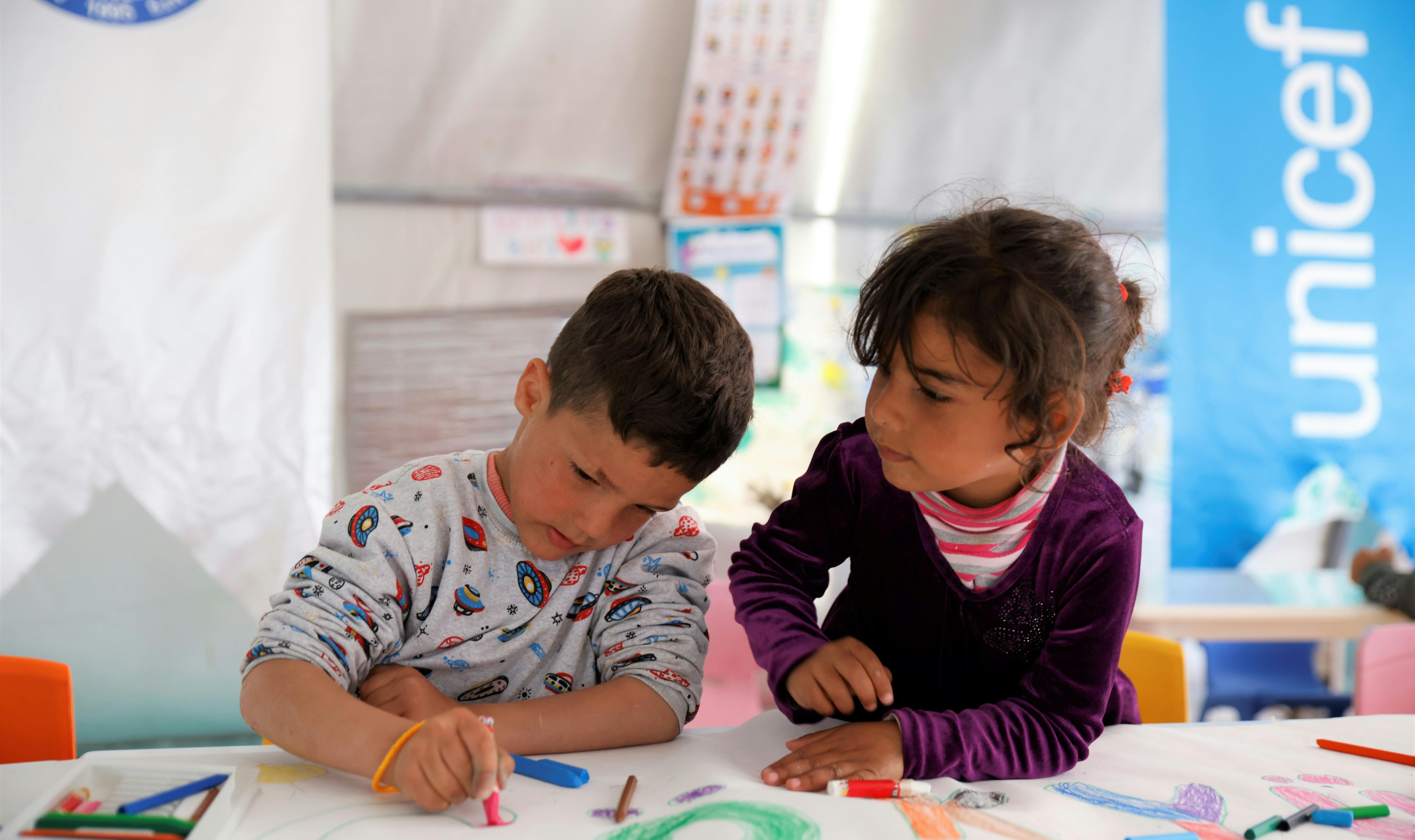 Due bambini disegnano durante una sessione di supporto psicosociale in un CFS dell'UNICEF in un rifugio temporaneo ad Antakya, dopo che due devastanti terremoti hanno colpito il sud-est della Turchia.