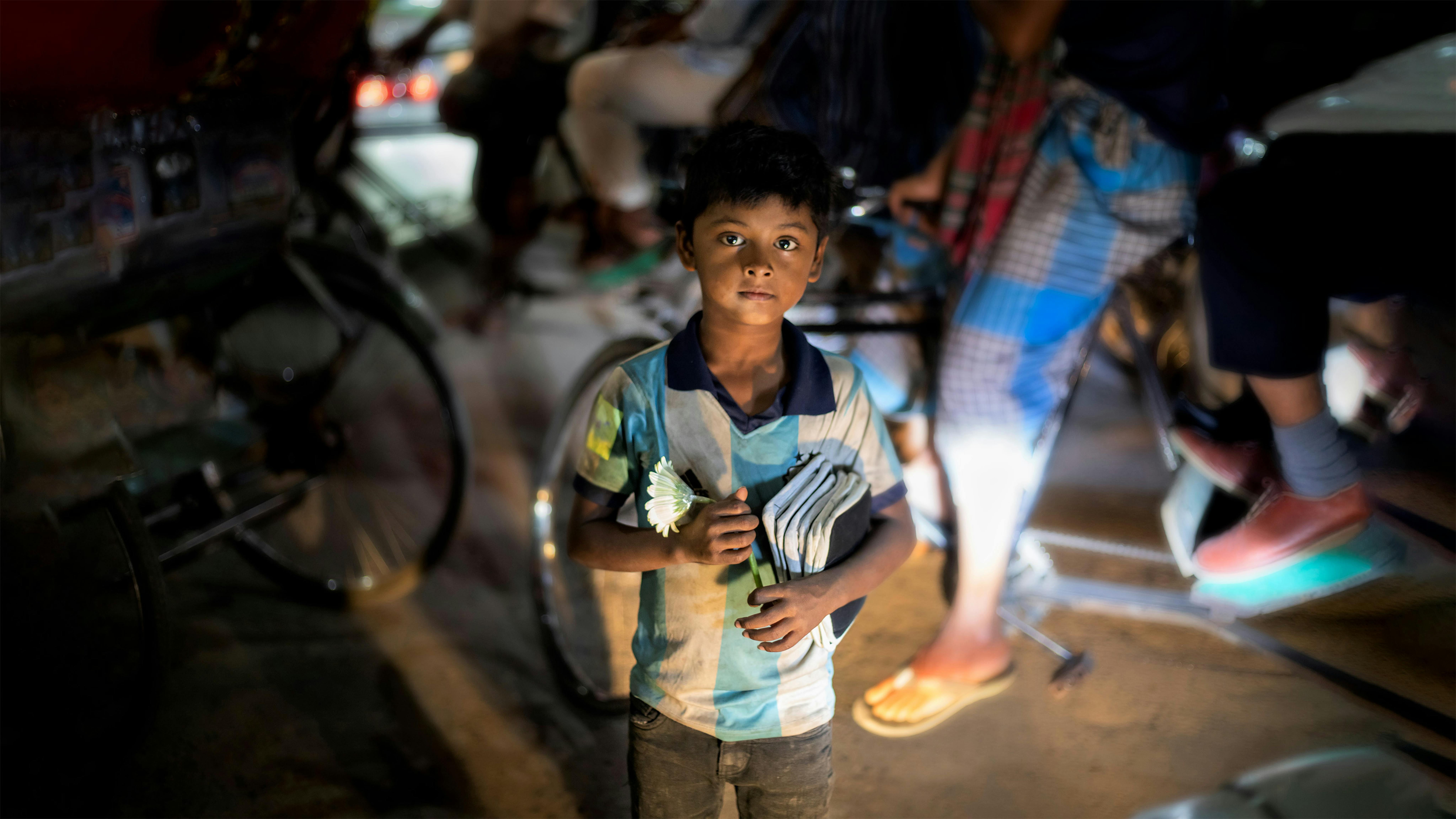 Bangladesh Un bambino che vive e lavora in situazioni di strada vende fiori e articoli per la casa per vivere nelle strade trafficate di Dhaka