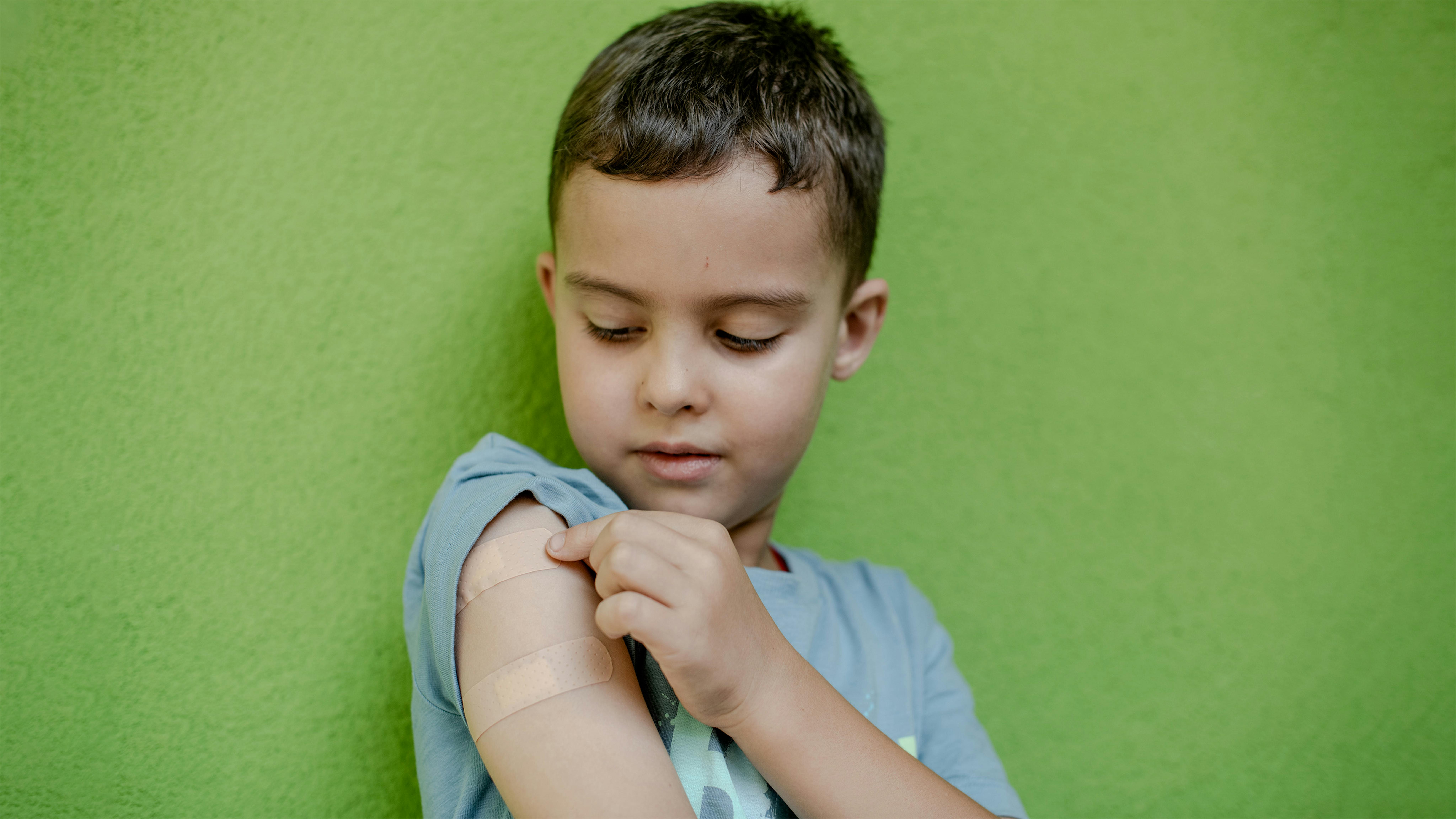 Polonia, Mykyta di 6 anni mostra il braccio dove è stato vaccinato © UNICEF/U.S. CDC/UN0715423/Kasia Strek