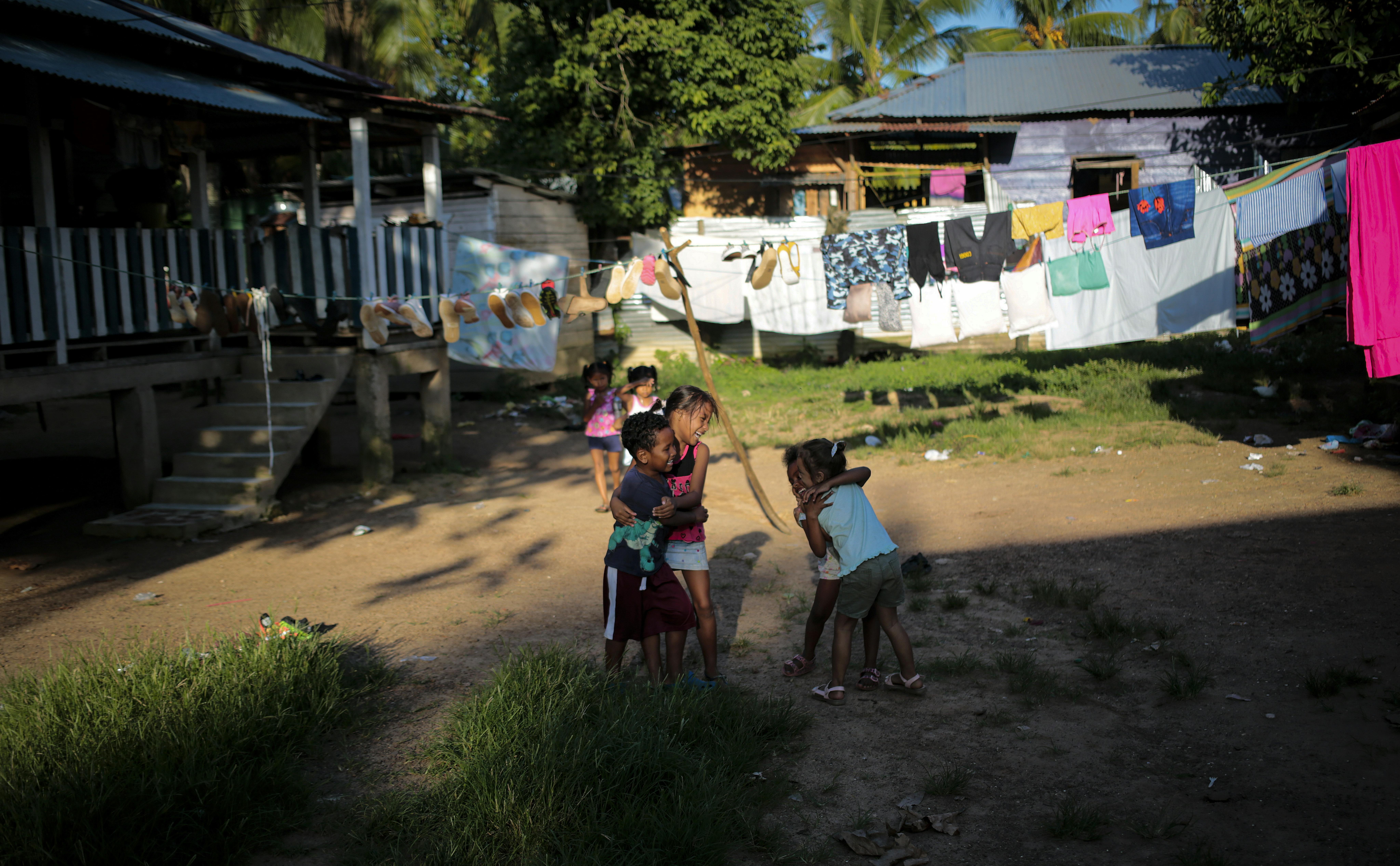 Thalia Chow Herrera, 7 anni, gioca con gli amici fuori casa mentre l'infermiera Kerlin Maynor prepara il vaccino da somministrarle. Siamo in Nicaragua, dove gli infermieri di comunità arrivano anche nelle comunità più difficili da raggiungere