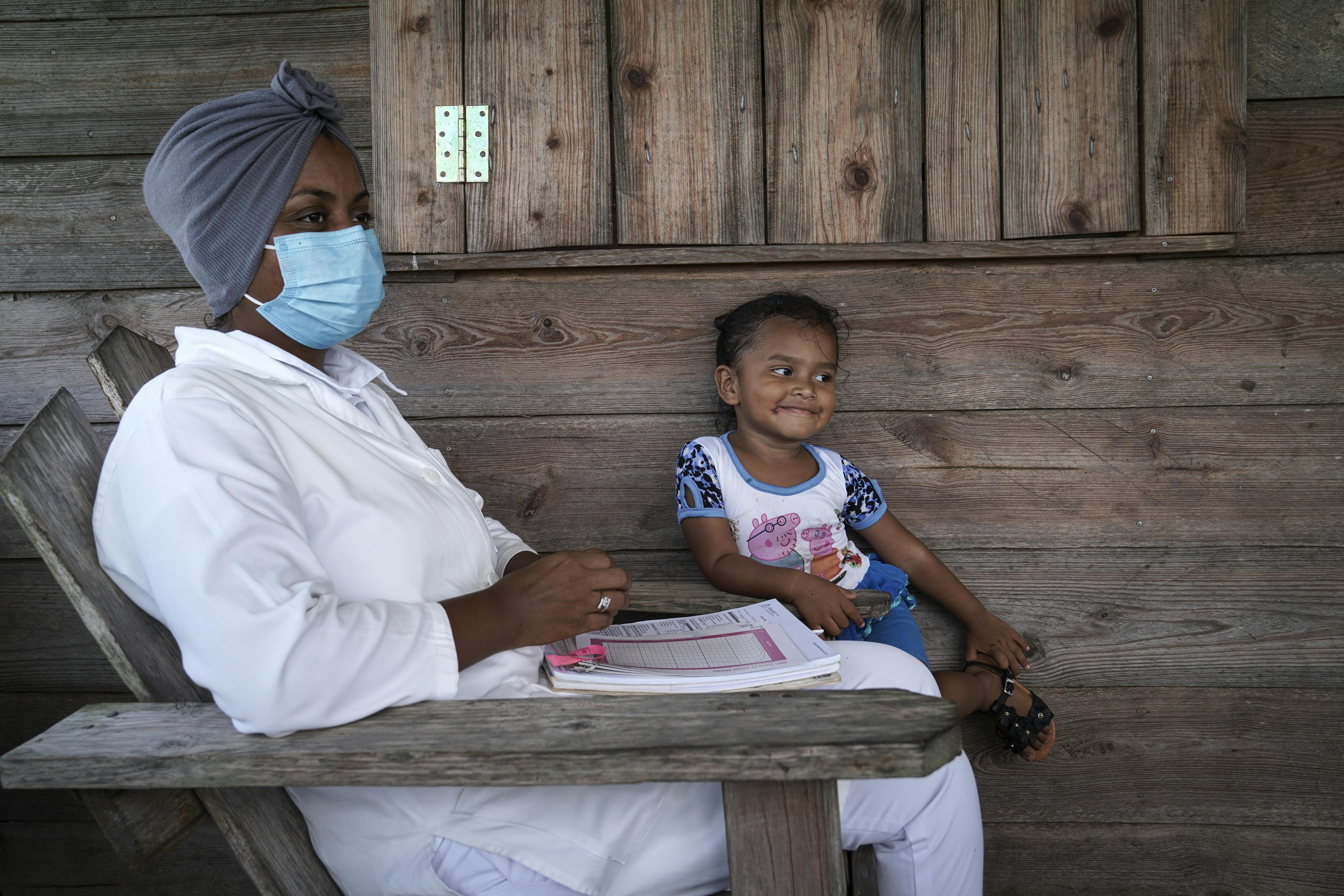 Un'infermiera parla della campagna di sensibilizzazione sulla vaccinazione pediatrica mentre Rihana, 3 anni, ascolta. Siamo nella comunità di Sisin, territorio indigeno di Twi Yahabra nei Caraibi del Nord del Nicaragua .