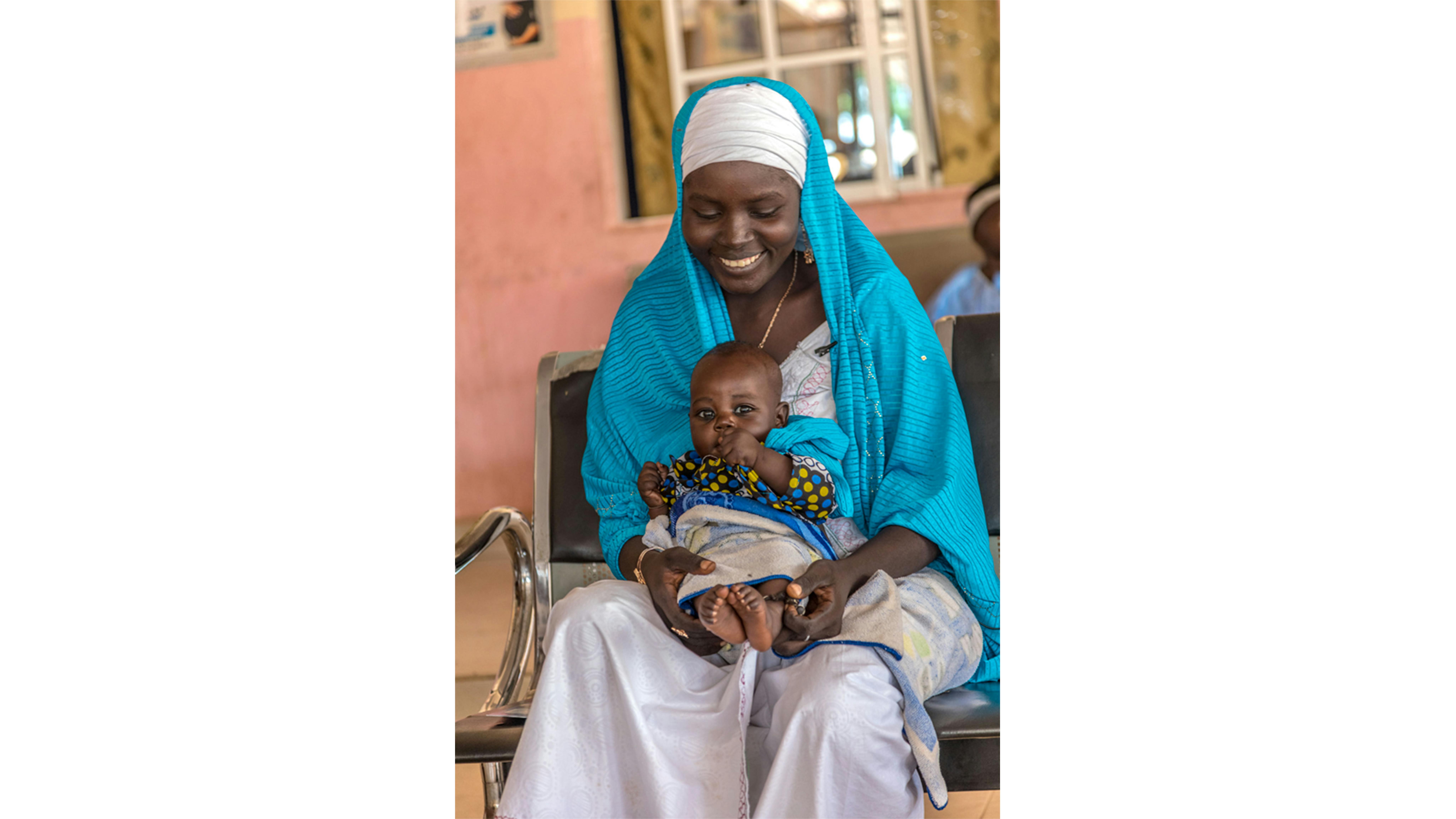 Nigeria-  Al Farang Primary Health Center, Maryam Abdulkadire tiene in braccio suo figlio Riliwanu Abdulkadire