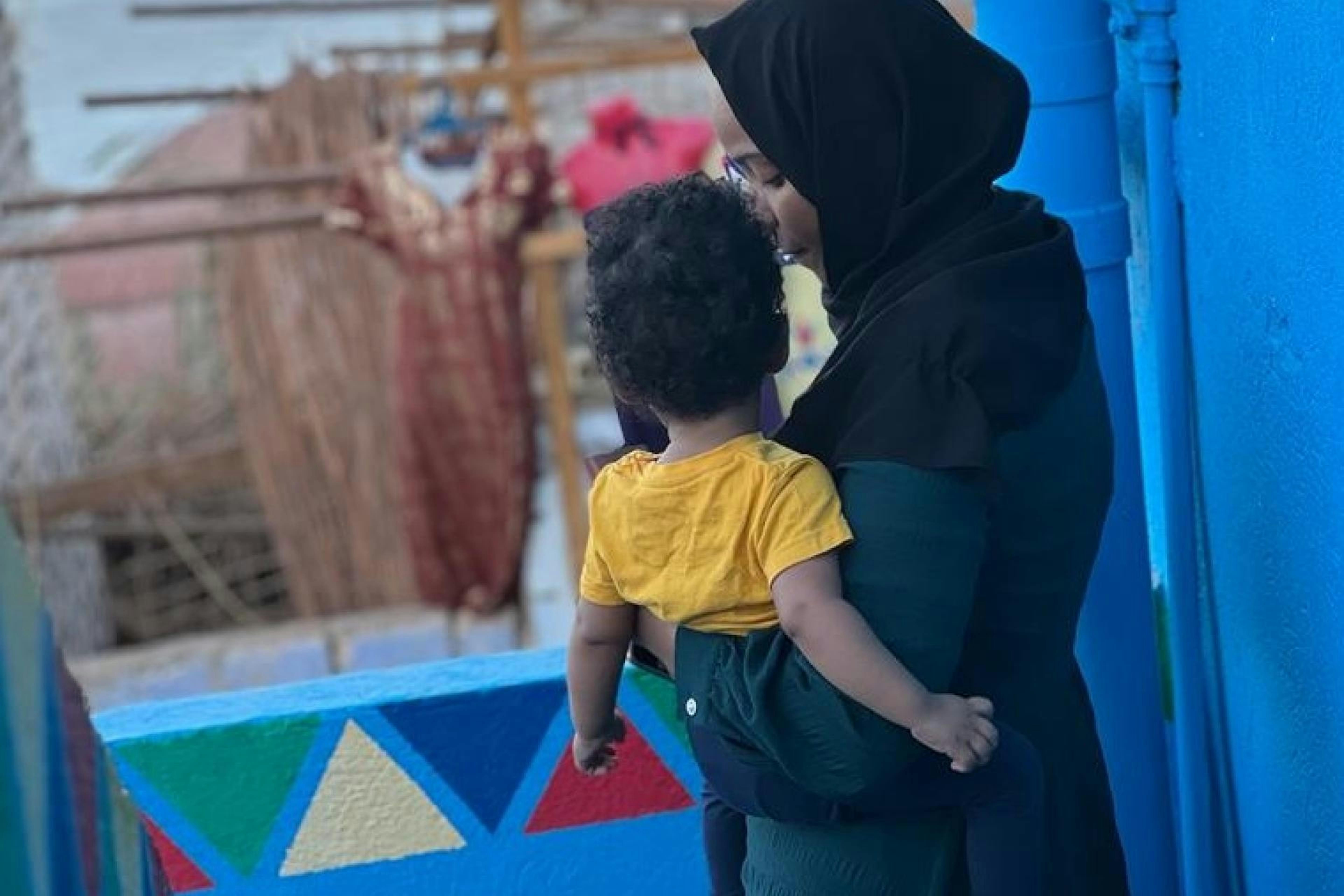 Marwa tiene in braccio il suo piccolo di 11 mesi: è dovuta fuggire dal Sudan a causa della violenza crescente, ora è in Egitto. Suo marito non riesce ancora a ricongiungersi con la famiglia