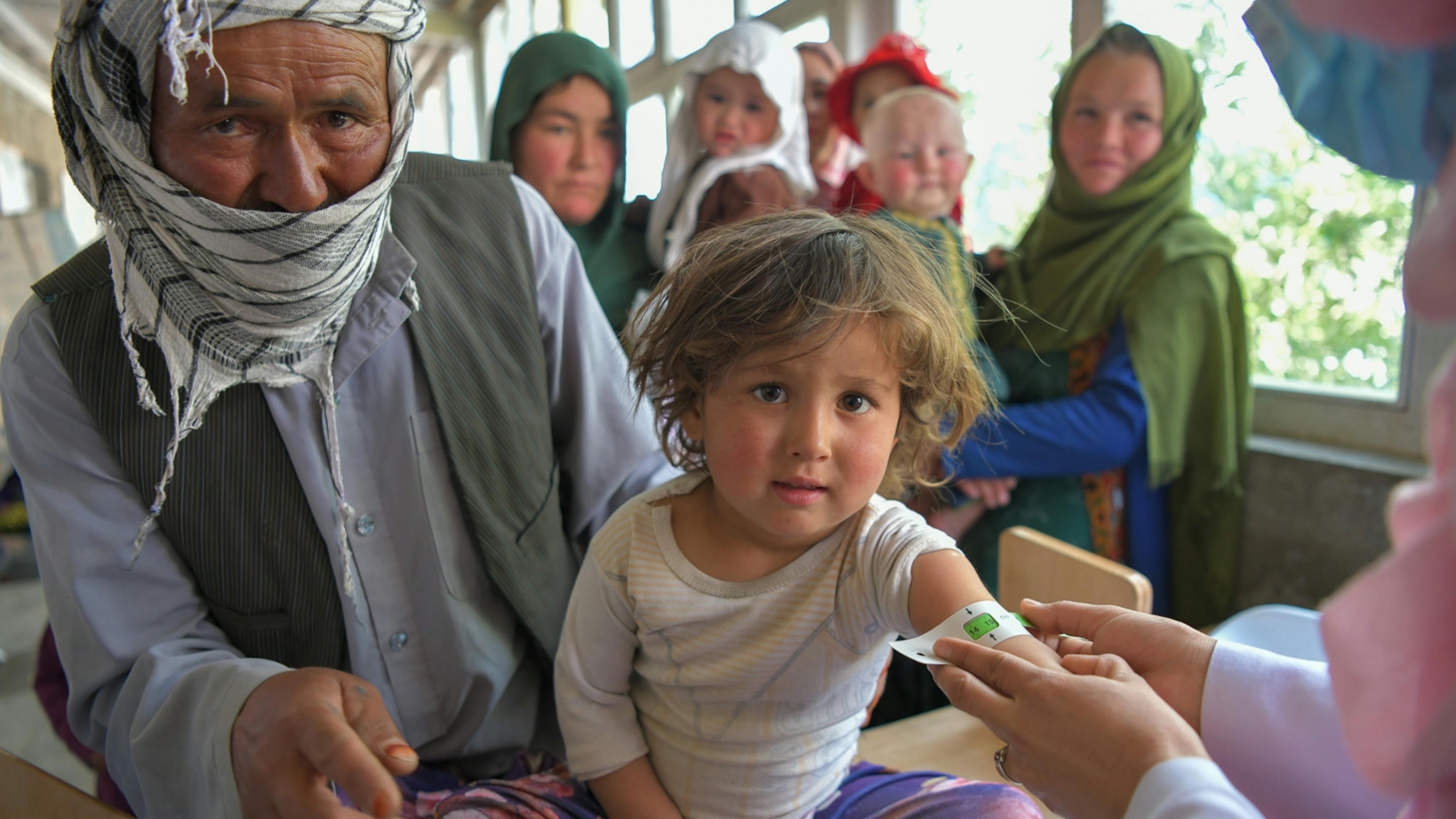 Afghanistan - il padre Sayed Ali porta sua figlia Atifa, 3 anni e 3 mesi, per lo screening dei segni di malnutrizione