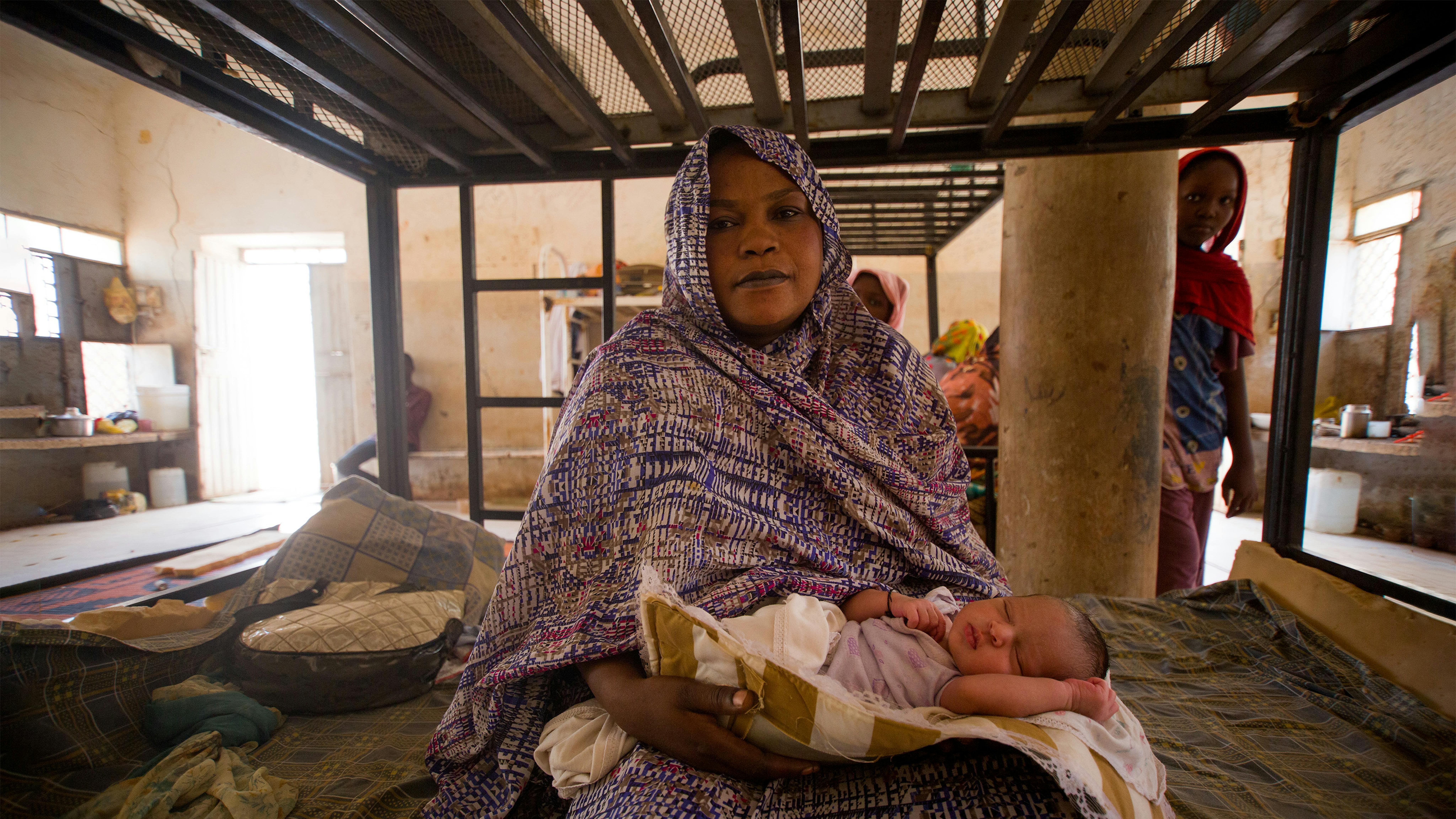 Hawa Abdallah Mahdi coccola il suo neonato Remaz che ha partorito nel rifugio temporaneo dopo che la sua famiglia è stata sfollata.