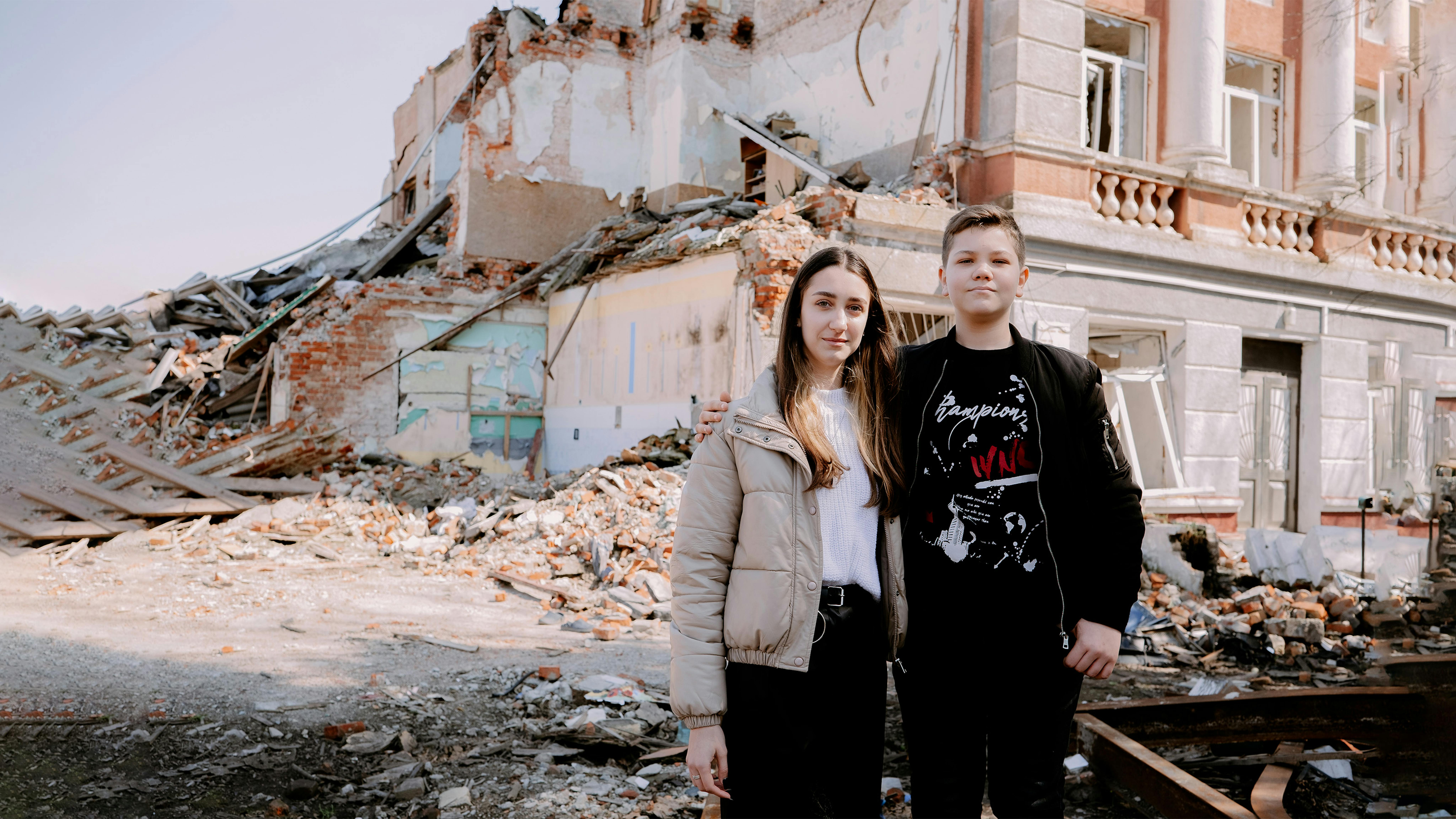 Ucraina - I fratelli Anastasia (17) e Mykhailo (12) davanti alla scuola distrutta a Eskhar.
