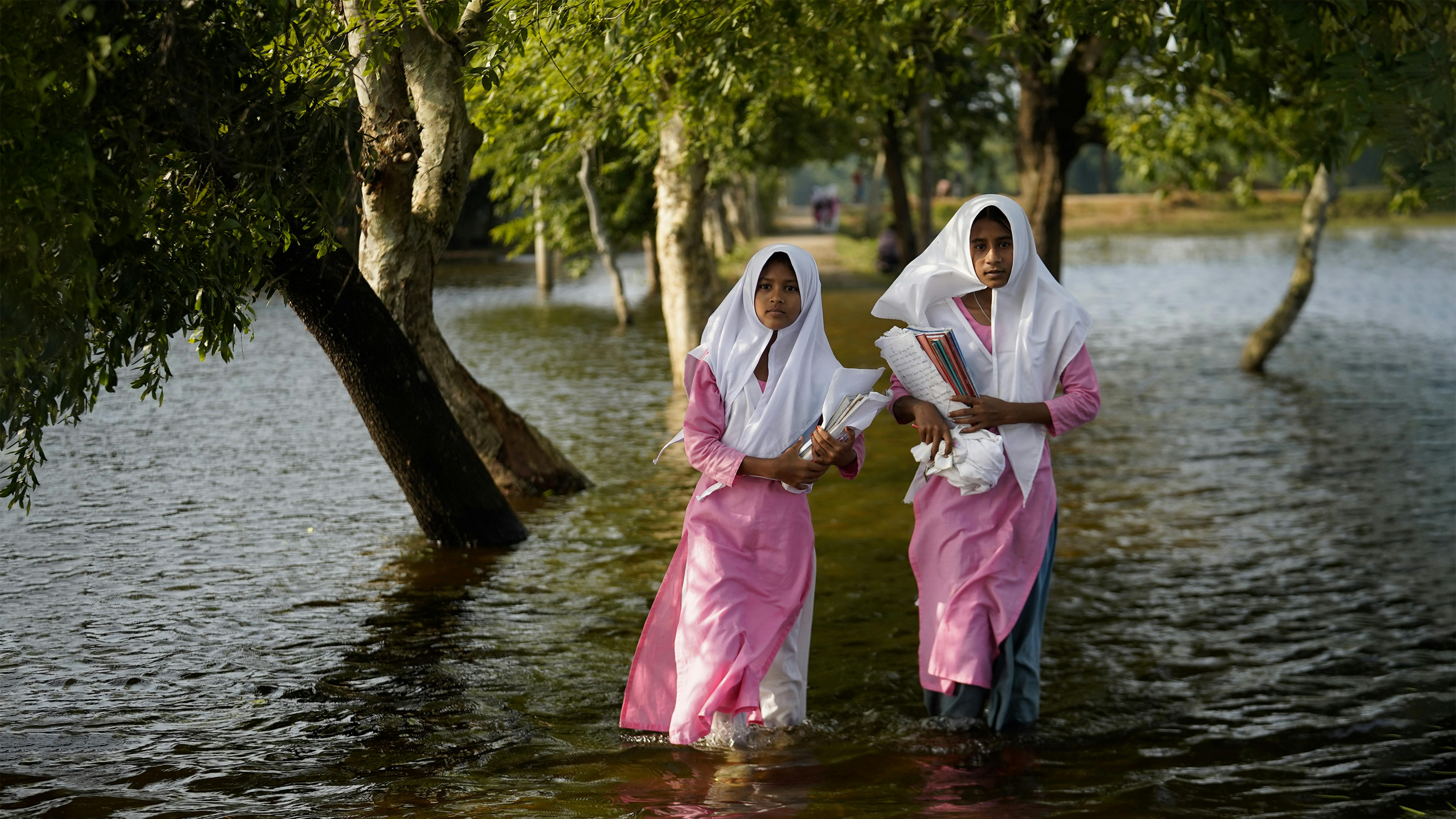 Bangladesh Le ragazze guadano le acque alluvionali mentre vanno a scuola a Sunamganj