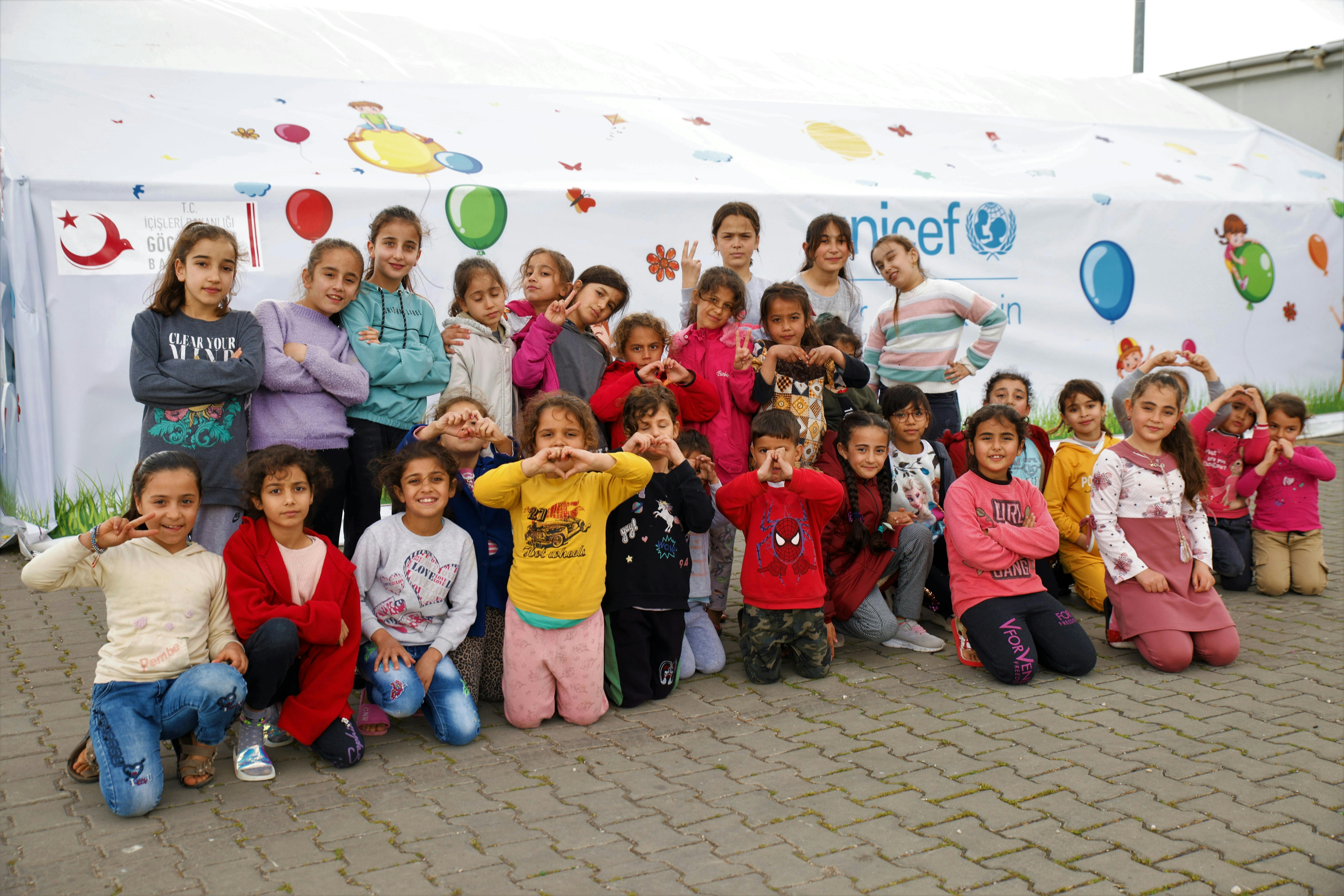 Bambini davanti a un Child Friendly Space dell'UNICEF in un rifugio temporaneo a Osmaniye, dopo che due devastanti terremoti hanno colpito il sud-est della Turchia.