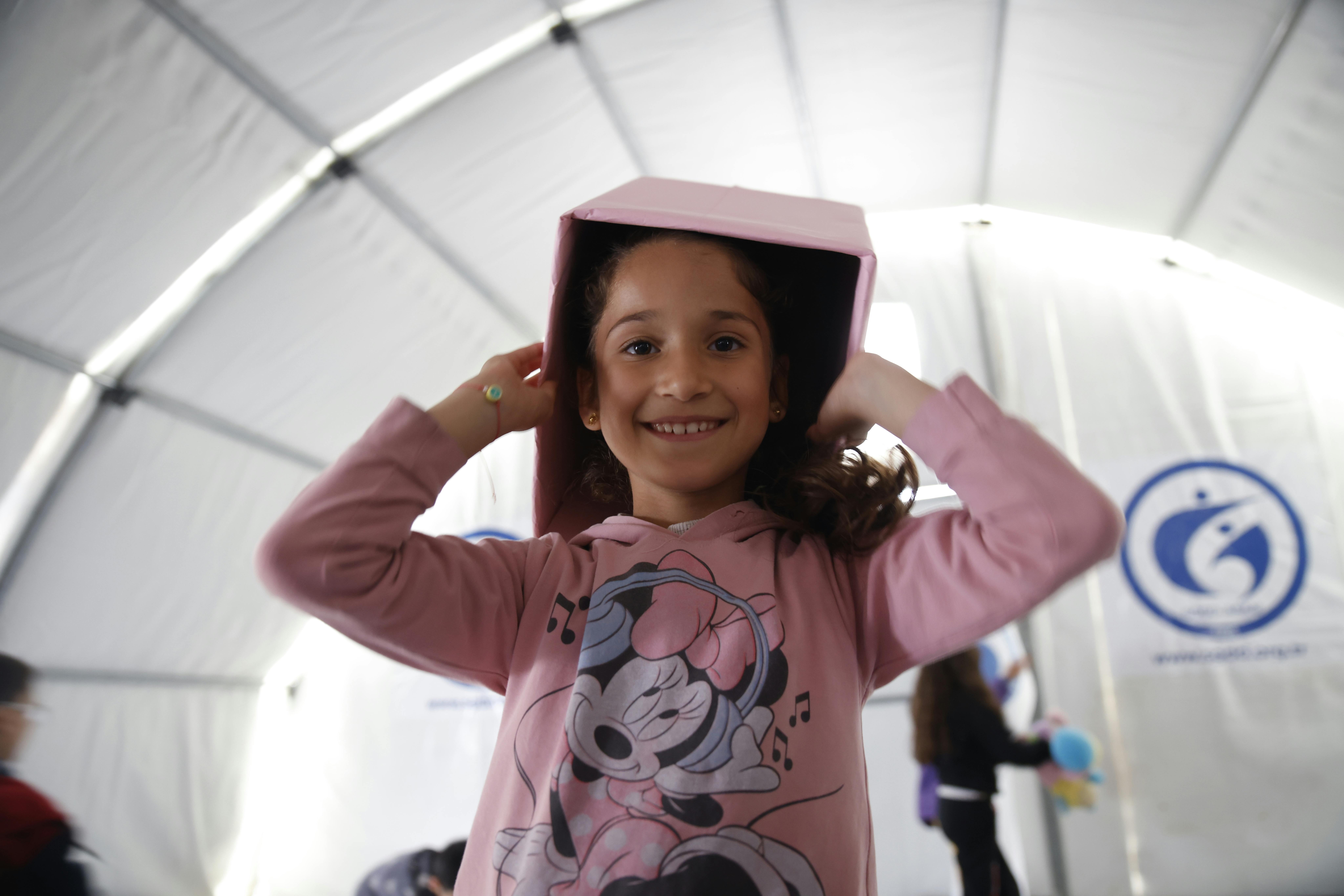 Turchia: una bambina indossa una scatola come cappello mentre si trova nel Child Friendly Space dell'UNICEF, allestito in un rifugio temporaneo dove si trovano le famiglie dopo i due devastanti terremoti hanno colpito il sud-est della Turchia.