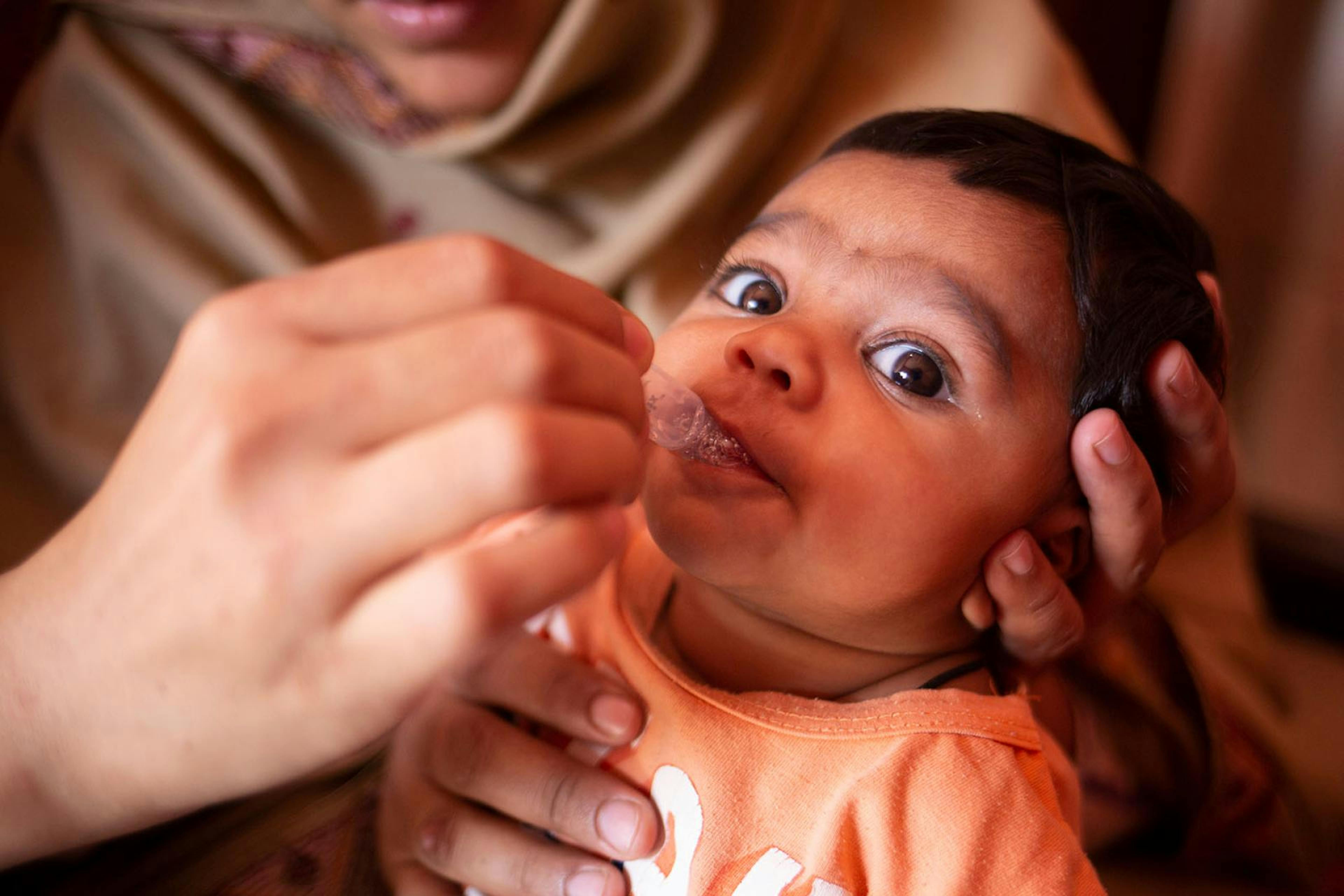 Pakistan, un operatore somministra una dose di vaccino orale