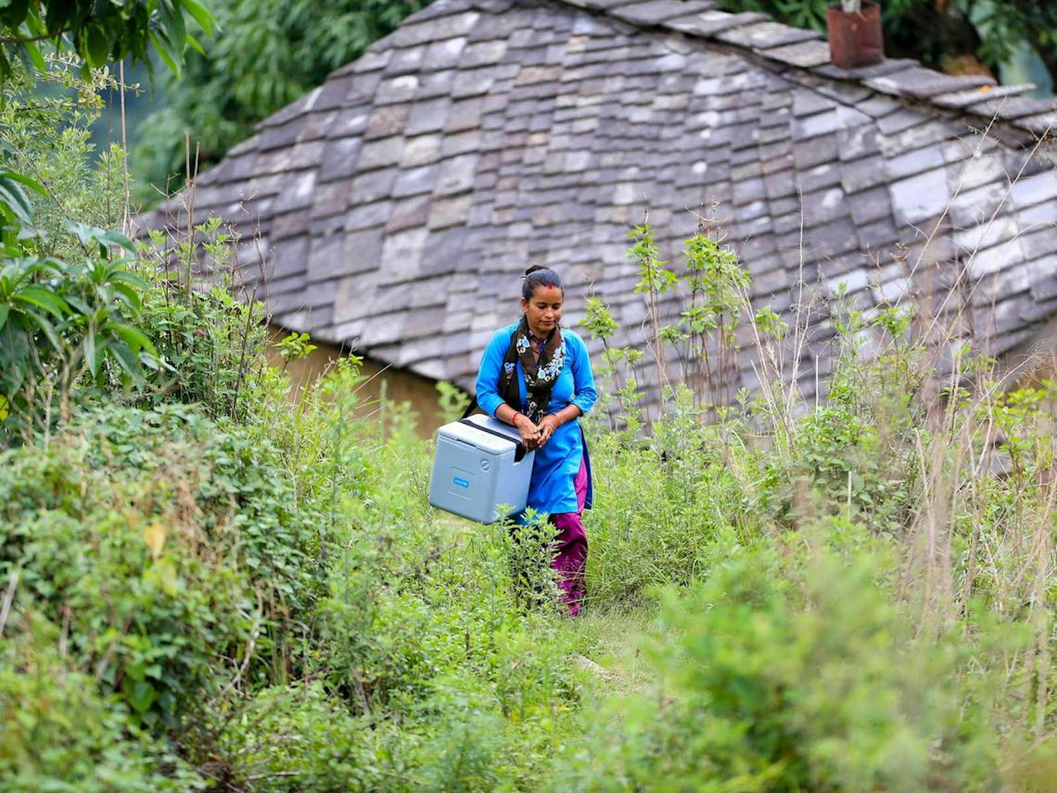 Nepal, un'operatrice sanitaria trasporta dosi di vaccino all'interno di un contenitore termico