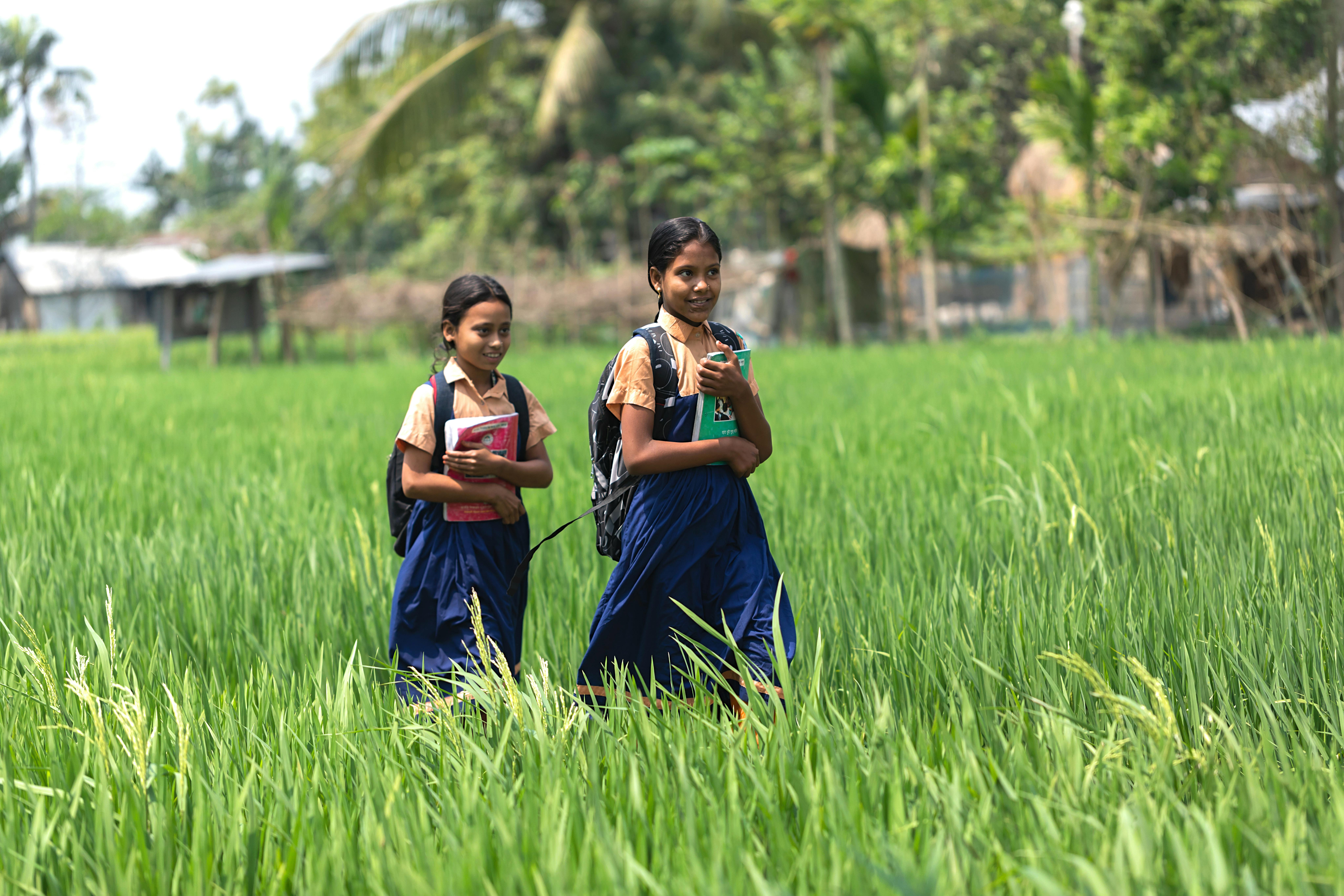 Shohana e la sua amica passeggiano lungo il sentiero che le porta a scuola. Sono dieci minuti di cammino tra le verdi risaie di Mymensingh, il villaggio in cui vivono in Bangladesh.