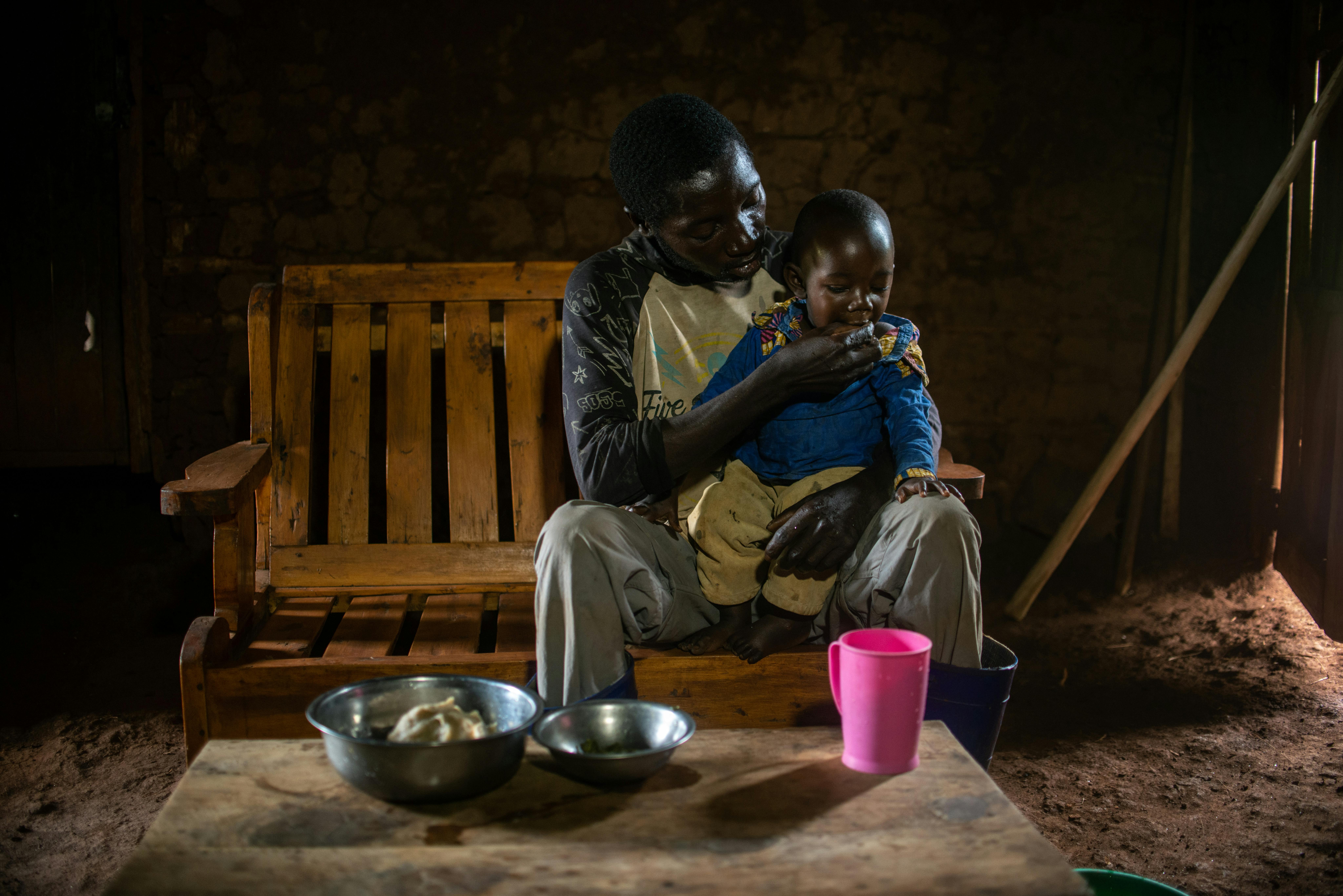 Antoine, un papà della RDC tiene in braccio suo figlio Ezechiéle, malnutrito