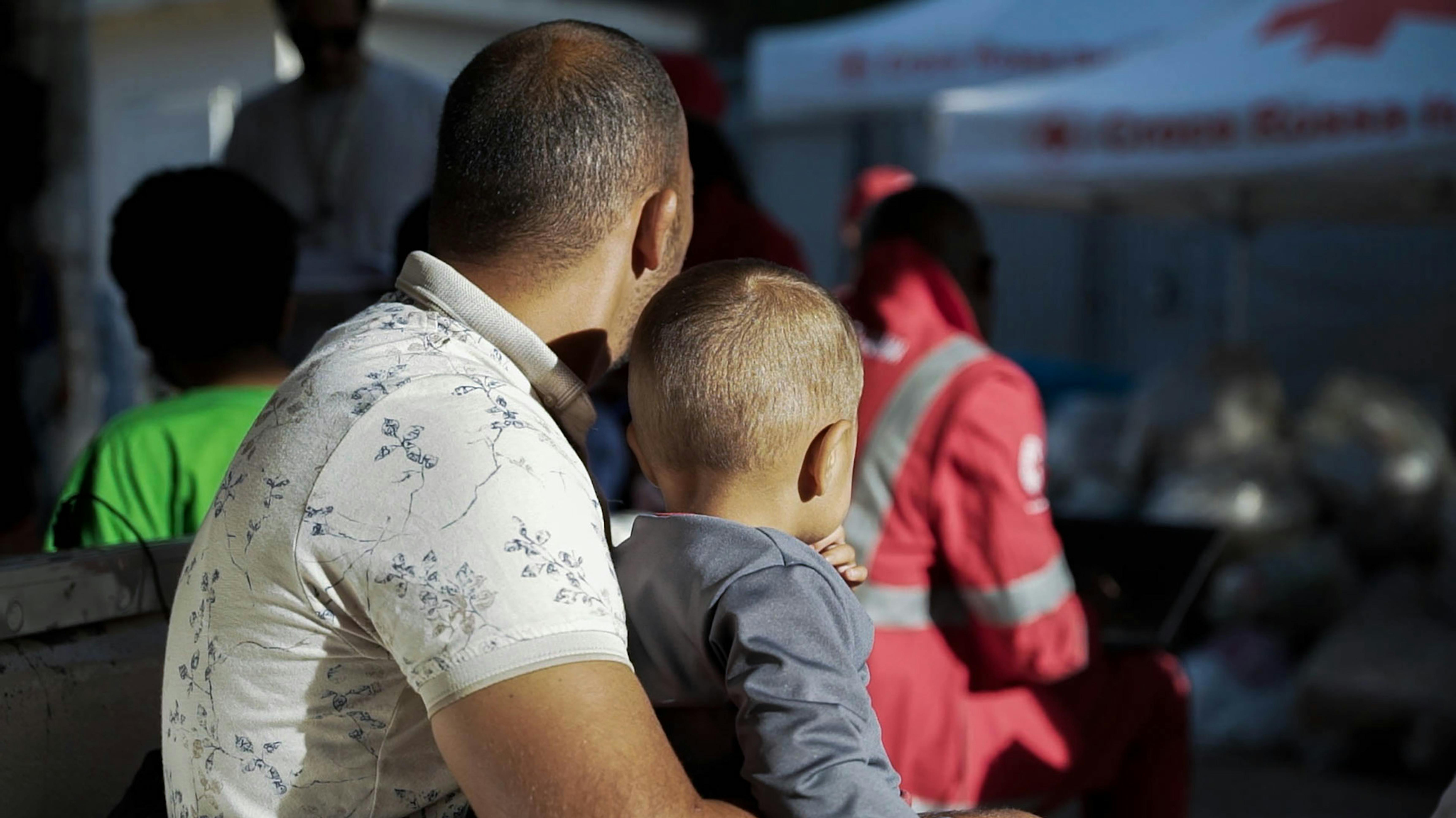 Italia - un bambino con il papà, migranti dalla Tunisia, presso la tenda della Croce Rossa a Lampedusa