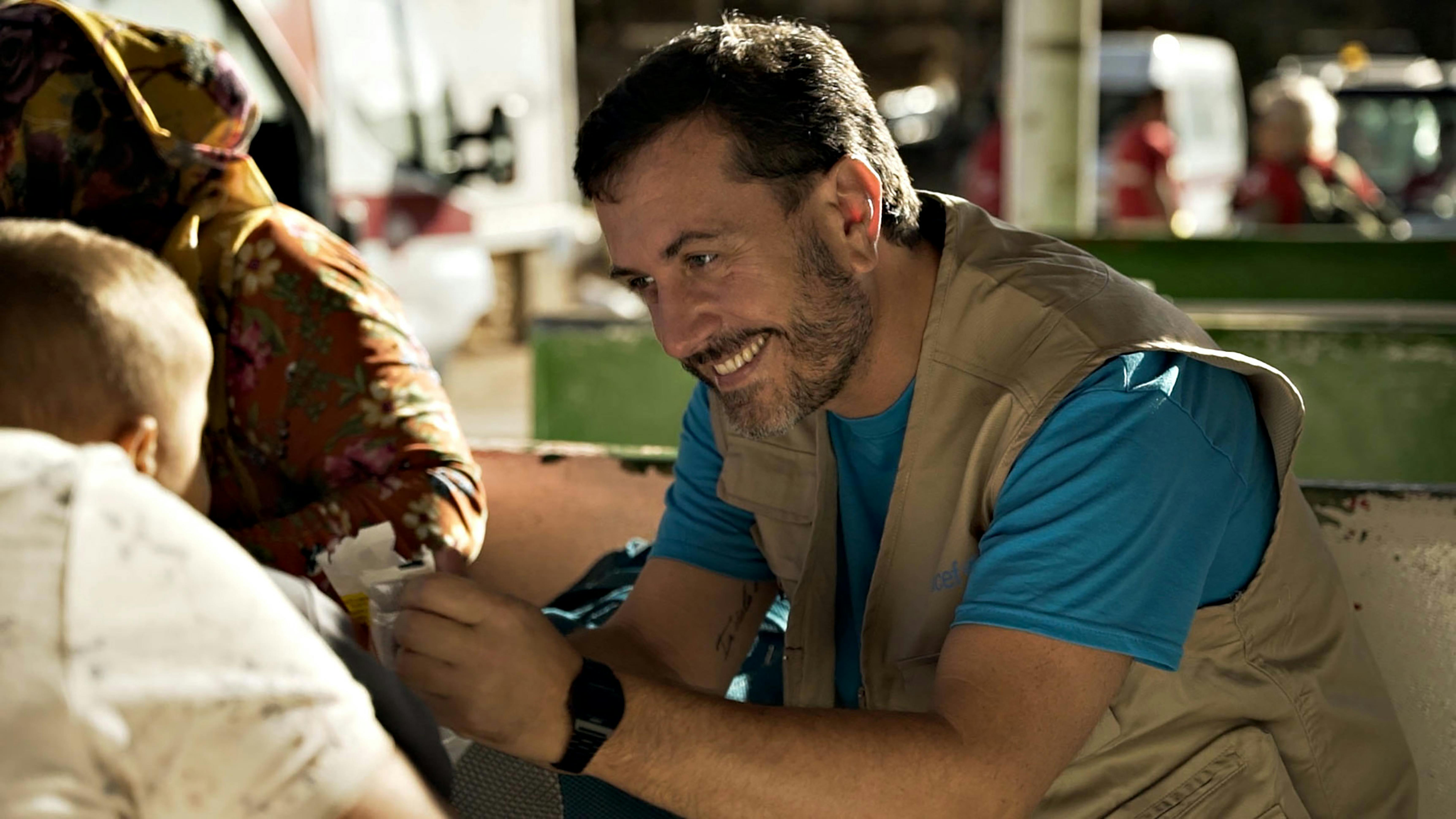 Andrea Iacomini, portavoce UNICEF Italia, sorride ad un bambino migrante approdato a Lampedusa