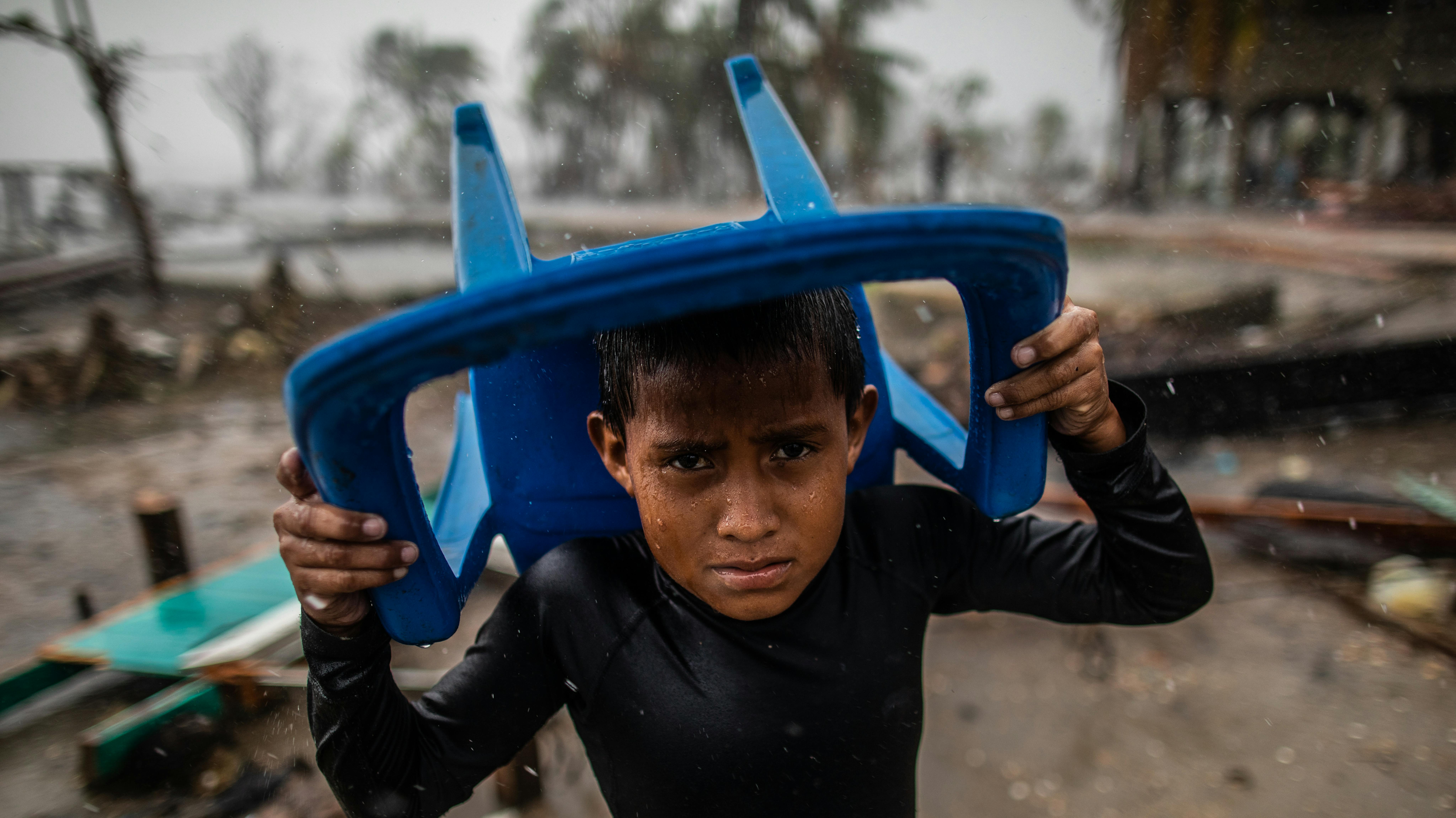 rain with a plastic chair, ​Controlla i dettagli 77 / 5.000 Risultati della traduzione Risultato di traduzione Nicaragua, un bambino si protegge dalla forte pioggia con una sedia di plastica,