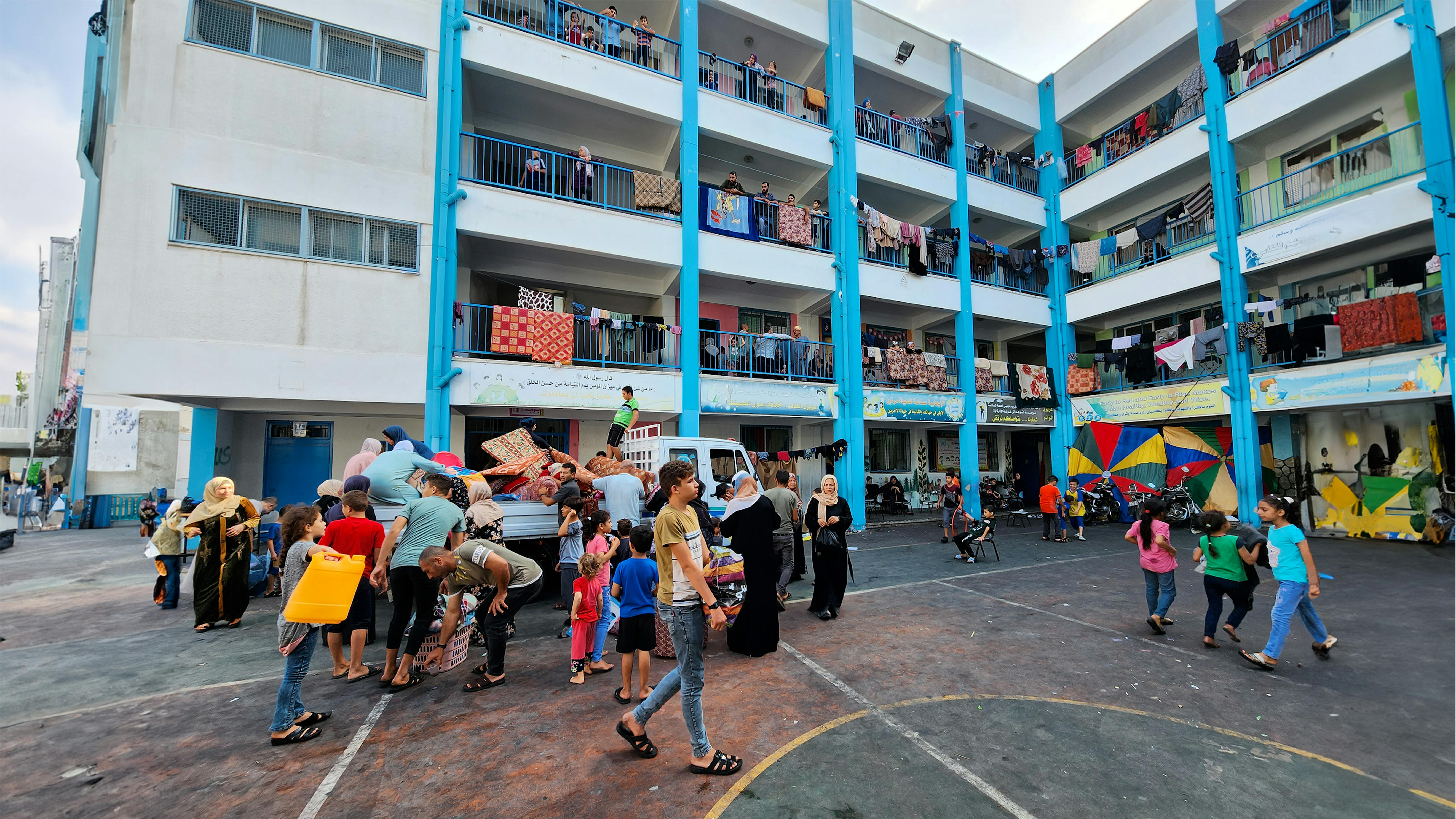 Le famiglie palestinesi con materassi, coperte e cuscini per trascorrere un'altra notte in una delle scuole dell'UNRWA utilizzate come rifugio durante l'escalation nella Striscia di Gaza.