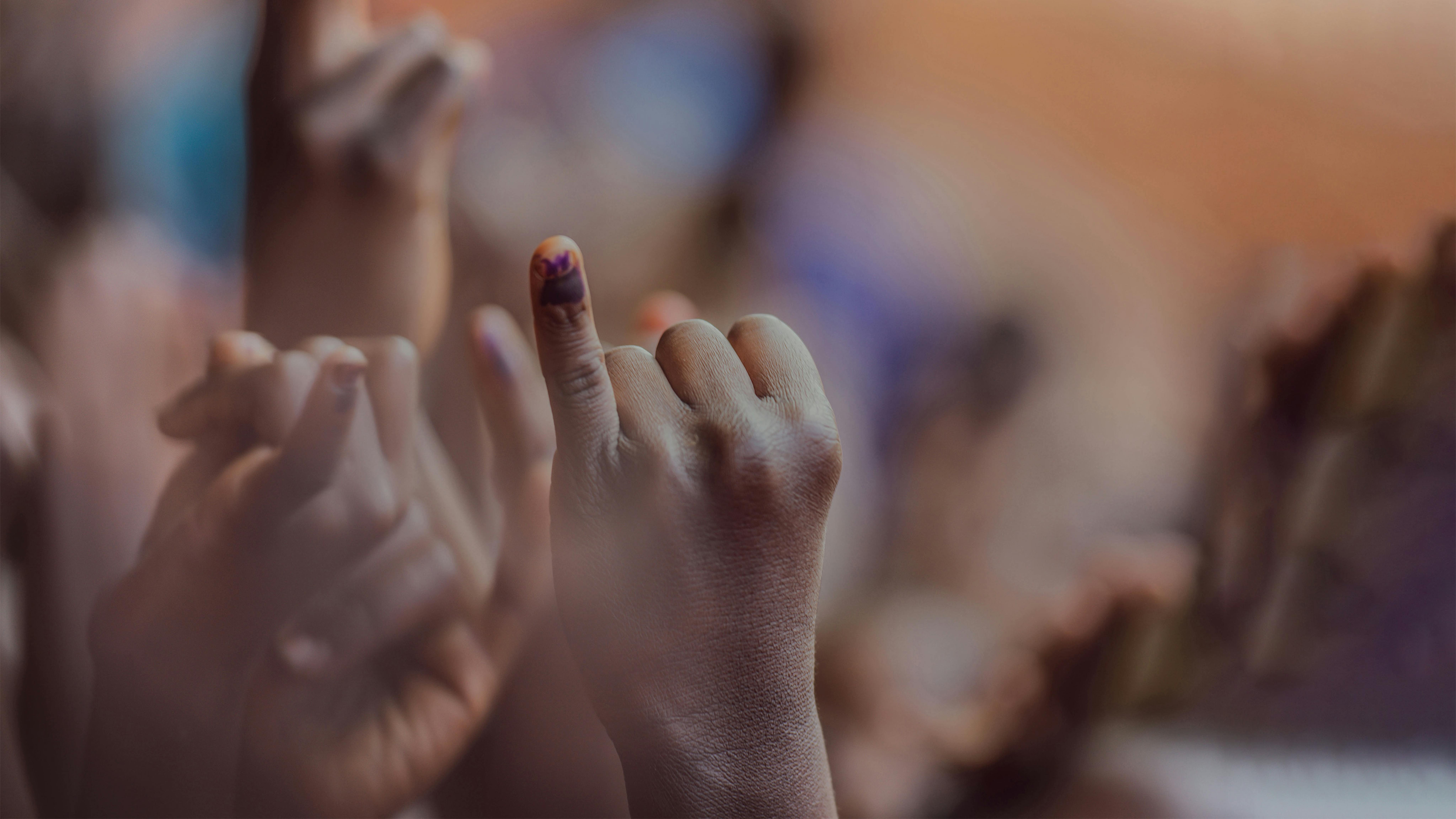 in Malawi, i bambini alzano i loro mignoli – che sono stati contrassegnati con penne viola – dopo essere stati vaccinati contro la poliomielite