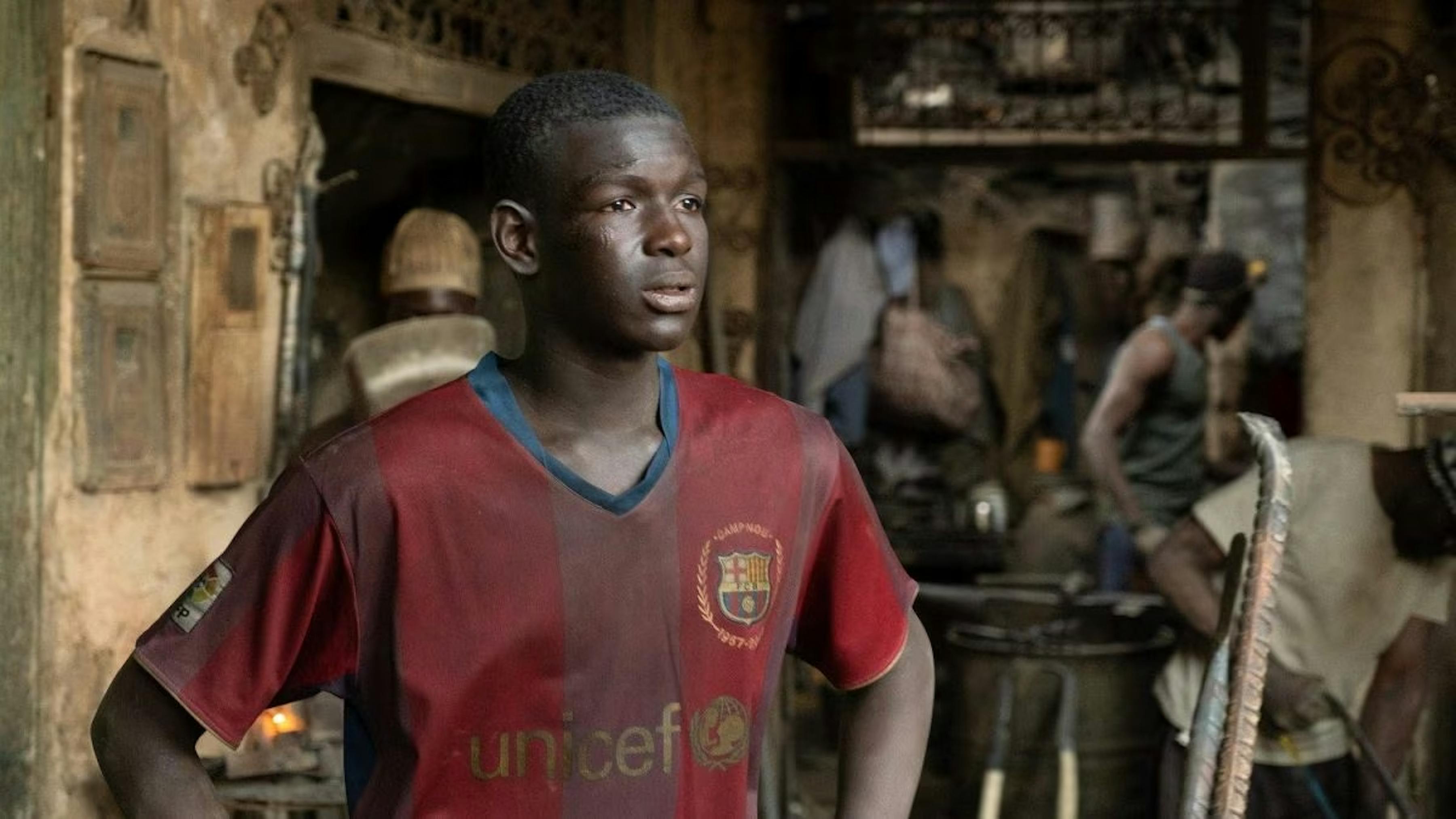 Film Io Capitano - il protagonista con la maglietta del Barcellona - logo UNICEF