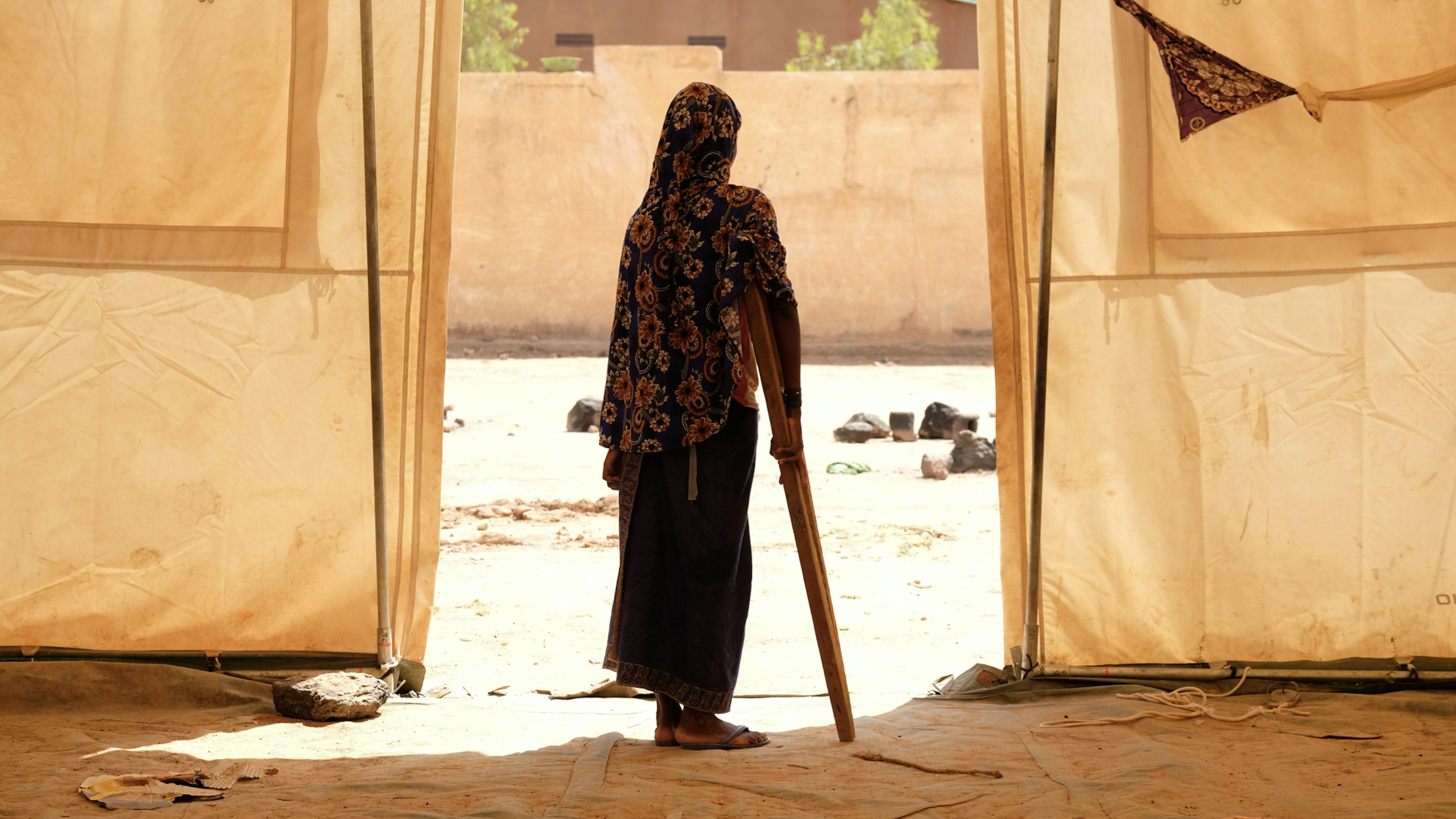Mali Aminata, una ragazza sfollata si appoggia alla stampella per camminare in un campo per sfollati a Sévaré, dove l'UNICEF, le autorità locali e i partner hanno installato sistemi di acqua pulita, tende per i rifugi e uno spazio di apprendimento temporaneo