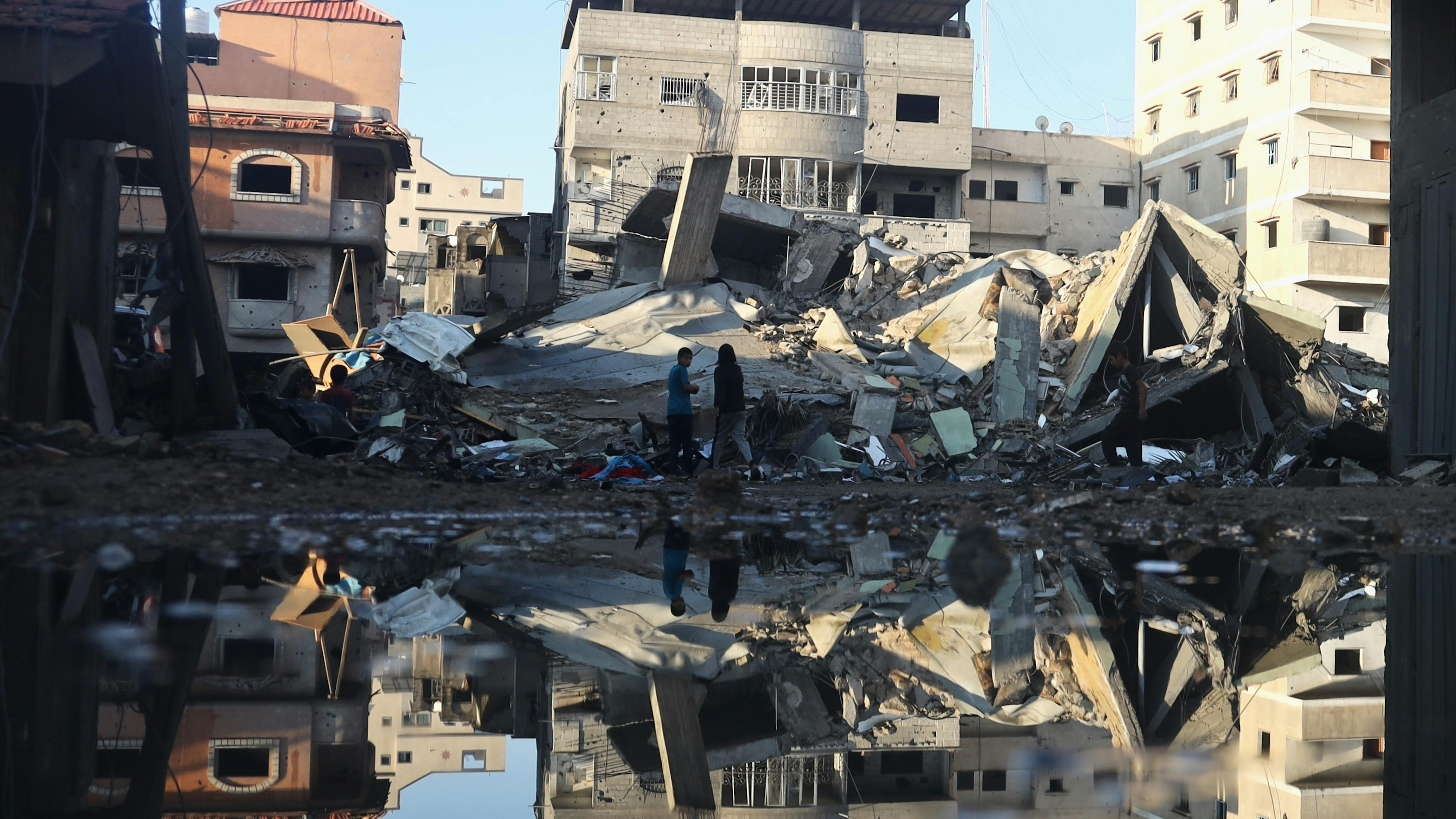 Le persone stanno cercando di rimuovere le macerie del loro quartiere distrutto dagli attacchi aerei sulla città di Rafah, nel sud della Striscia di Gaza.