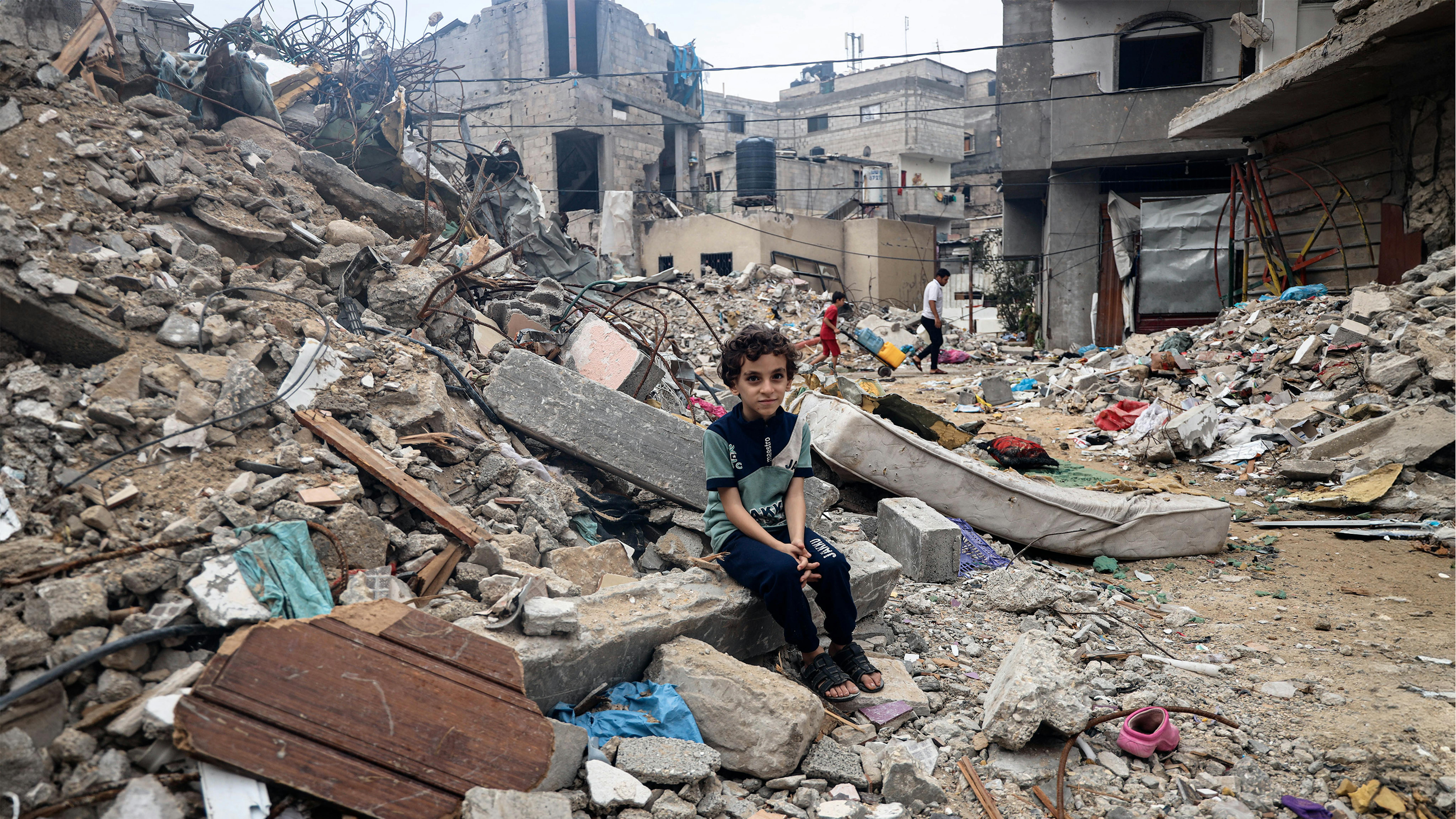 Mohammed Alattar, 8 anni, della città di Rafah, siede sulle macerie della casa della sua famiglia, che è stata bombardata...