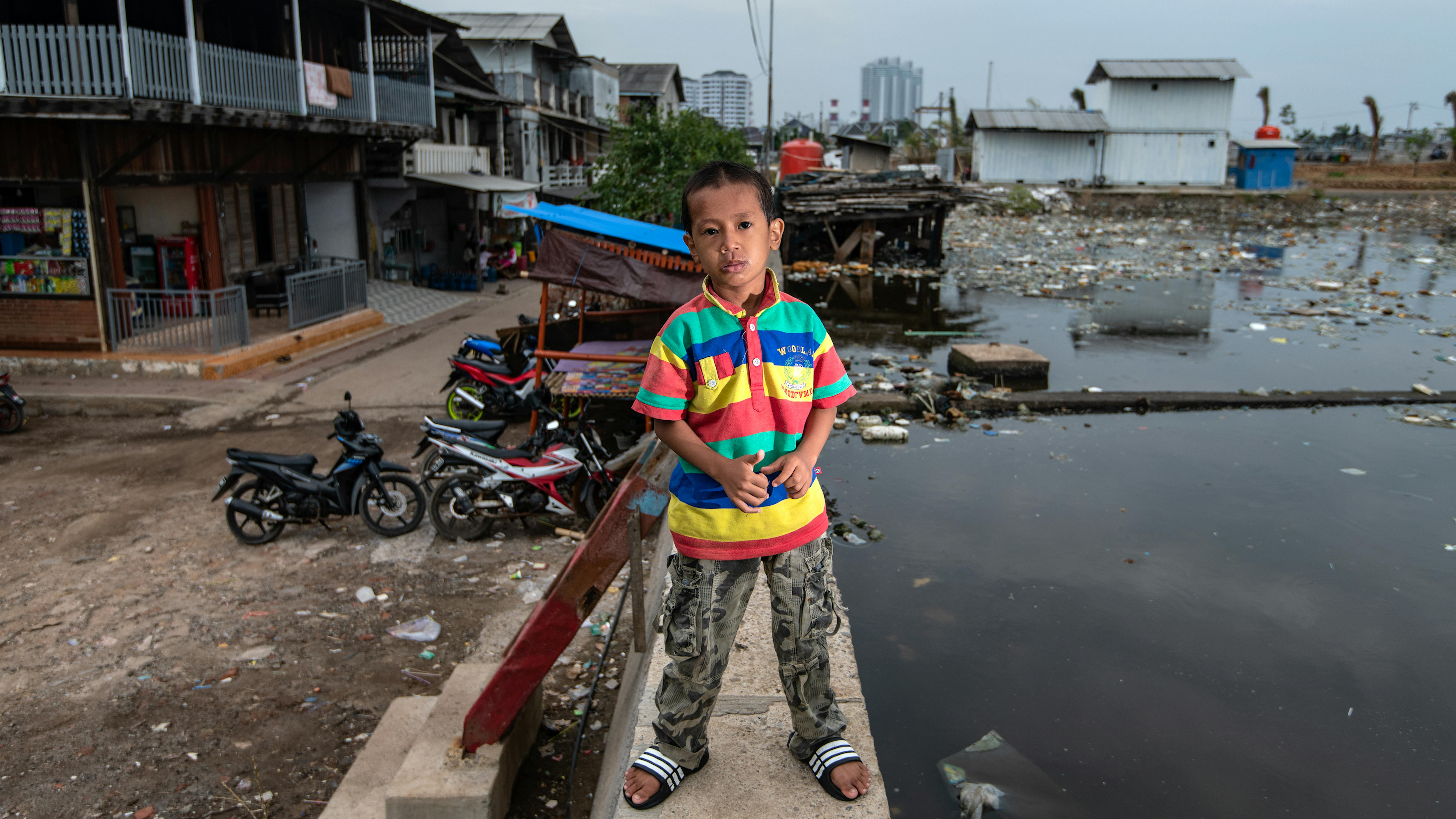 Indonesia - Satrio Widodo, in piedi su una diga vicino alla sua casa nel quartiere Muara Baru a nord di Giakarta