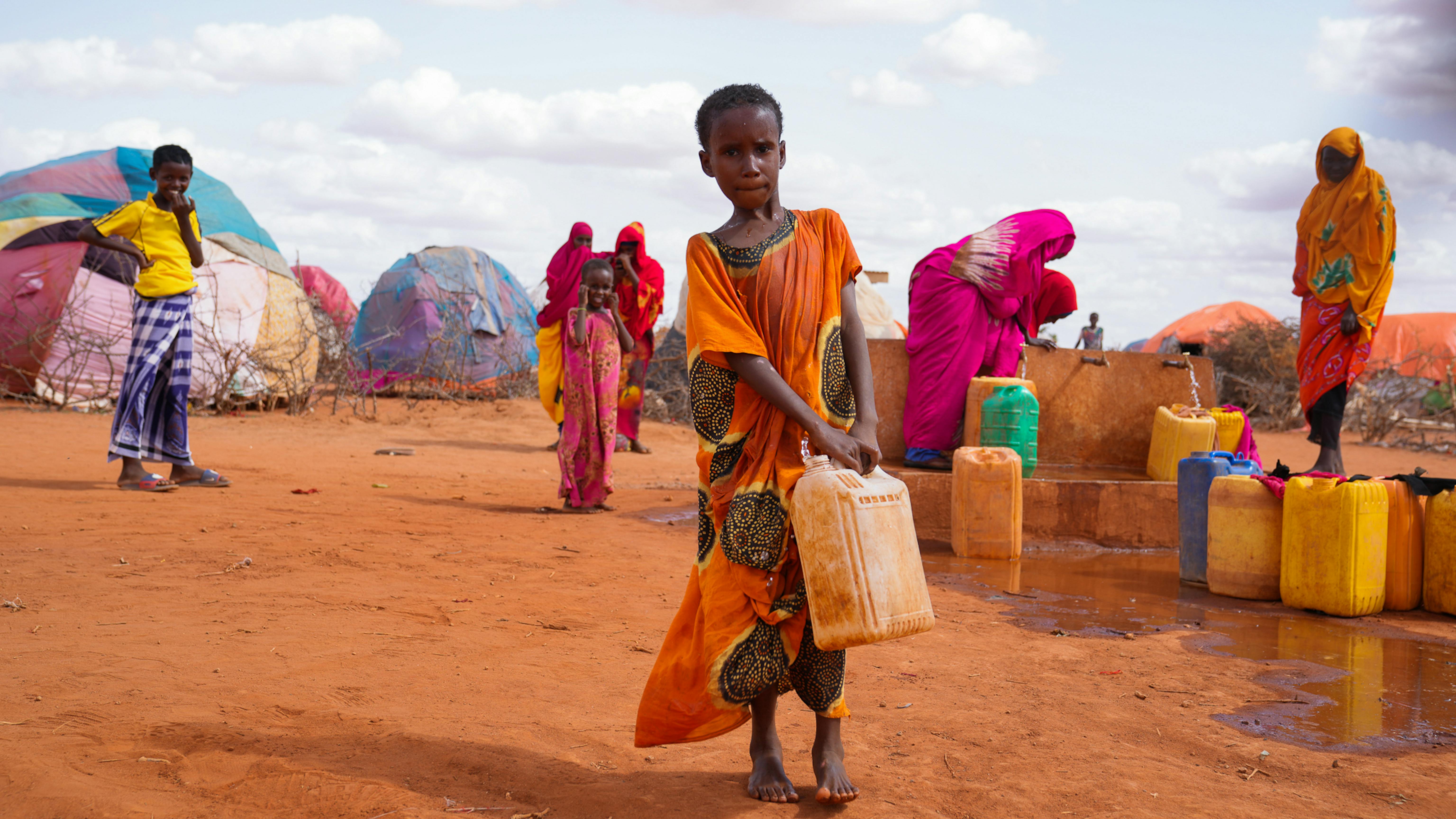 Somalia Hibo, una bambina di 10 anni, trasporta l'acqua in una tanica nella sua casa temporanea nel campo per sfollati di Kaharey a Dollow
