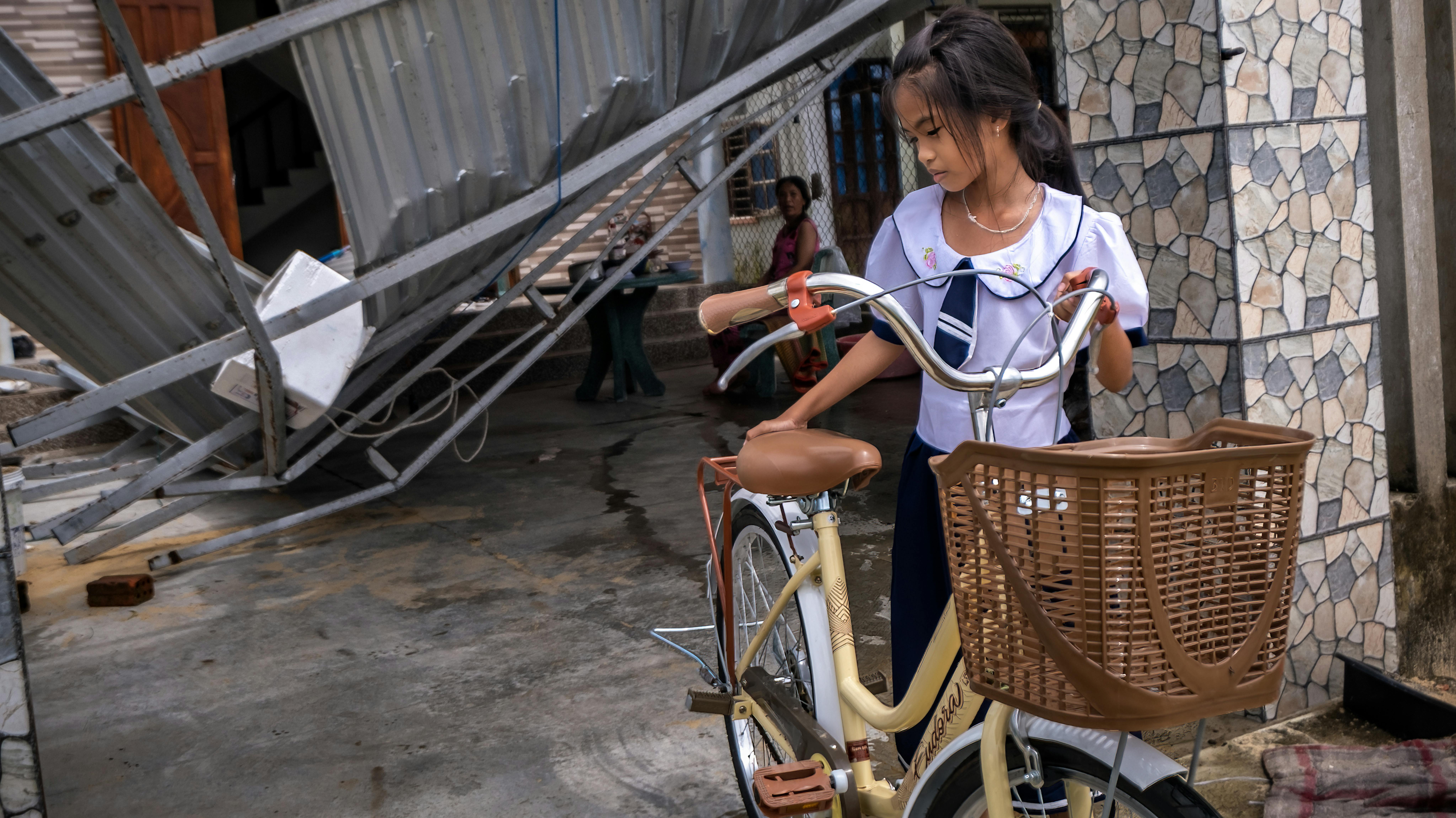 Viet Nam - Nguyễn Thị Bích Trâm, 8 anni,  con la bicicletta davanti alla sua casa il cui tetto è stato spazzato via dal tifone Noru o
