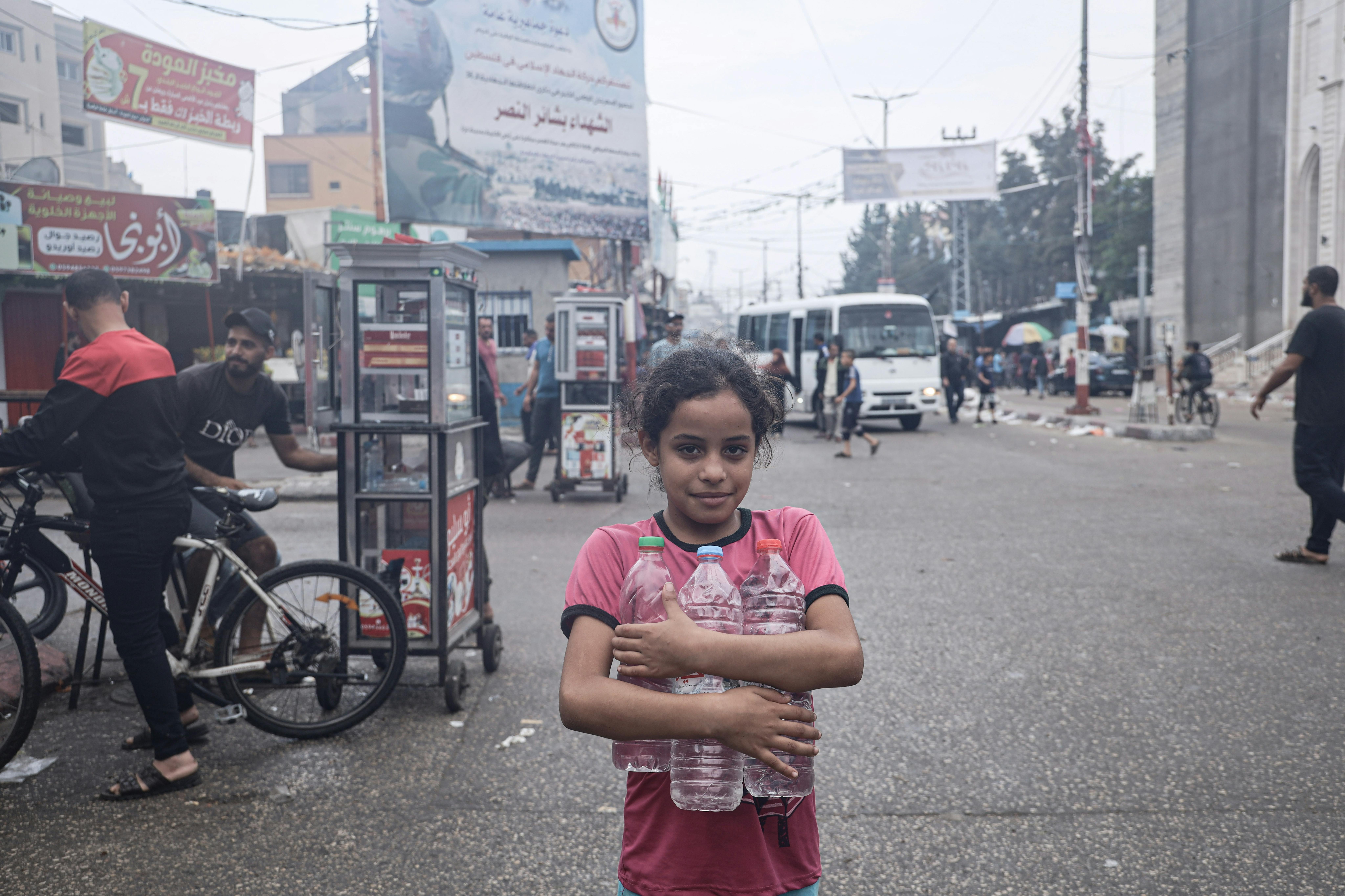 Salwa Elyan, 8 anni abbraccia delle bottiglie vuote per poterle riempire e poi portare dalla sua famiglia.“Da grande vorrei fare l’infermiera. Spero che la guerra finisca subito. Amo tutti i bambini, non voglio che muoiano come noi”.