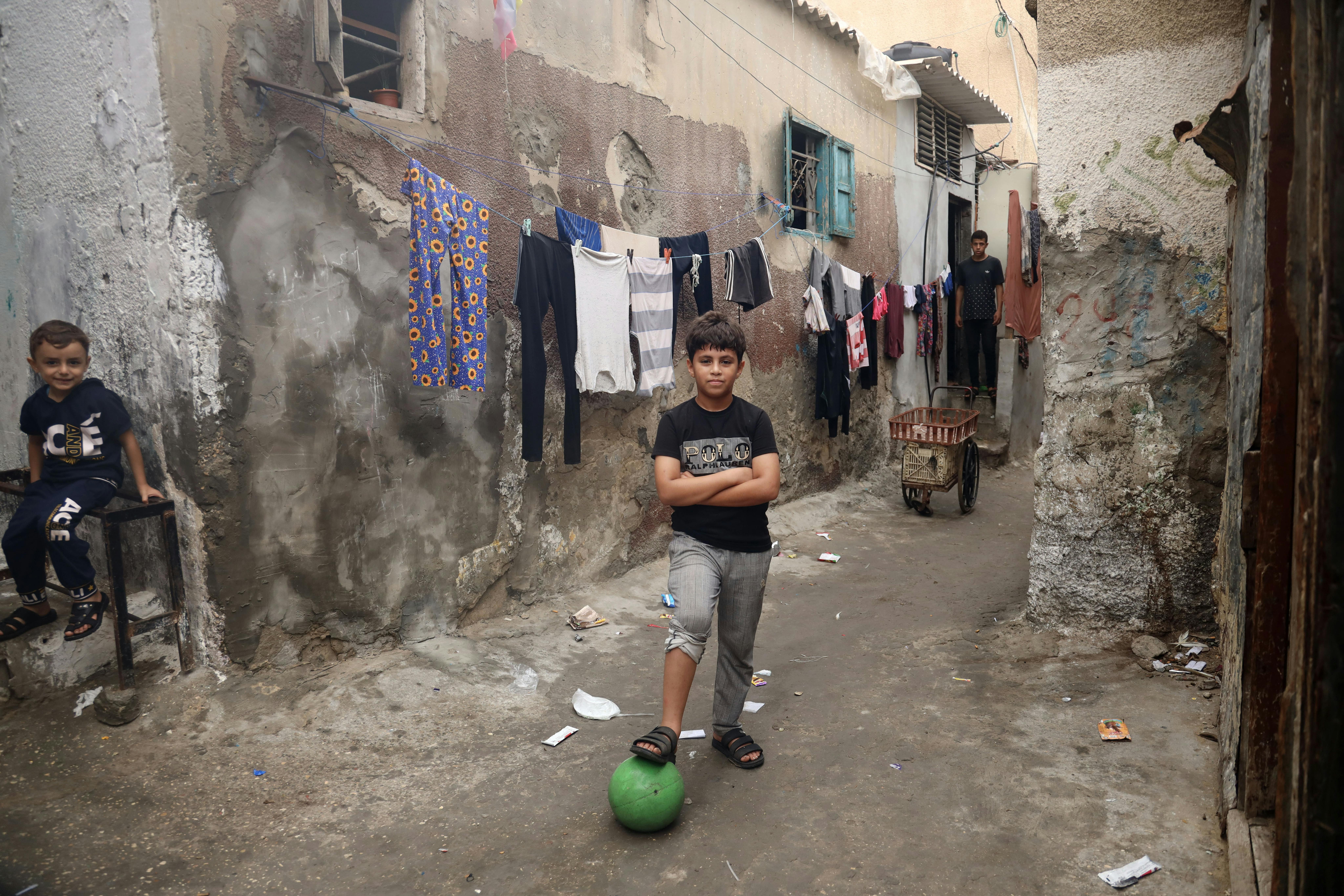 Yousef Al Hams gioca a calcio in mezzo alla strada con un suo amico nella città di Rafah. 