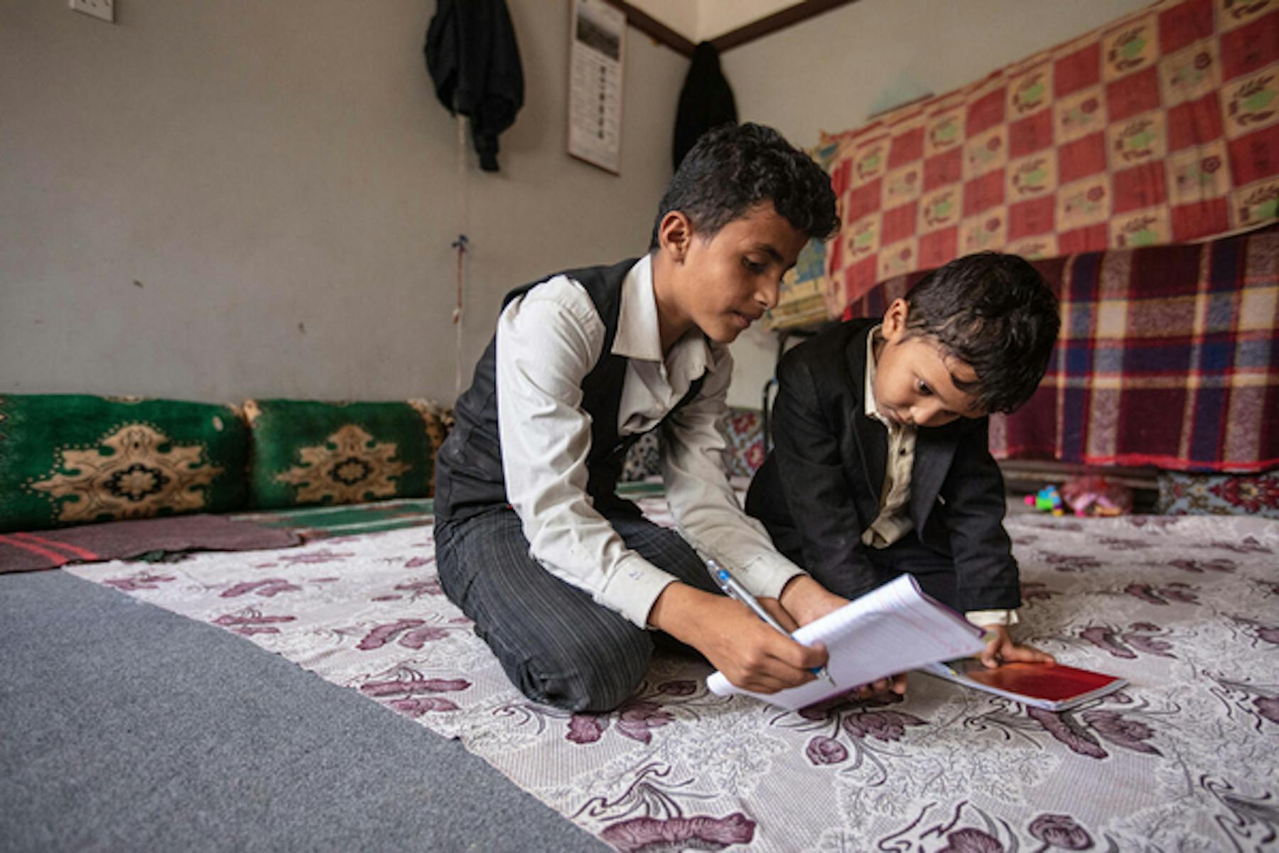 Ahmed, 12 anni, e il fratello Mohammed di 6 anni, fanno i compiti "a casa" un'aula della scuola Al-Hamzi, in Yemen