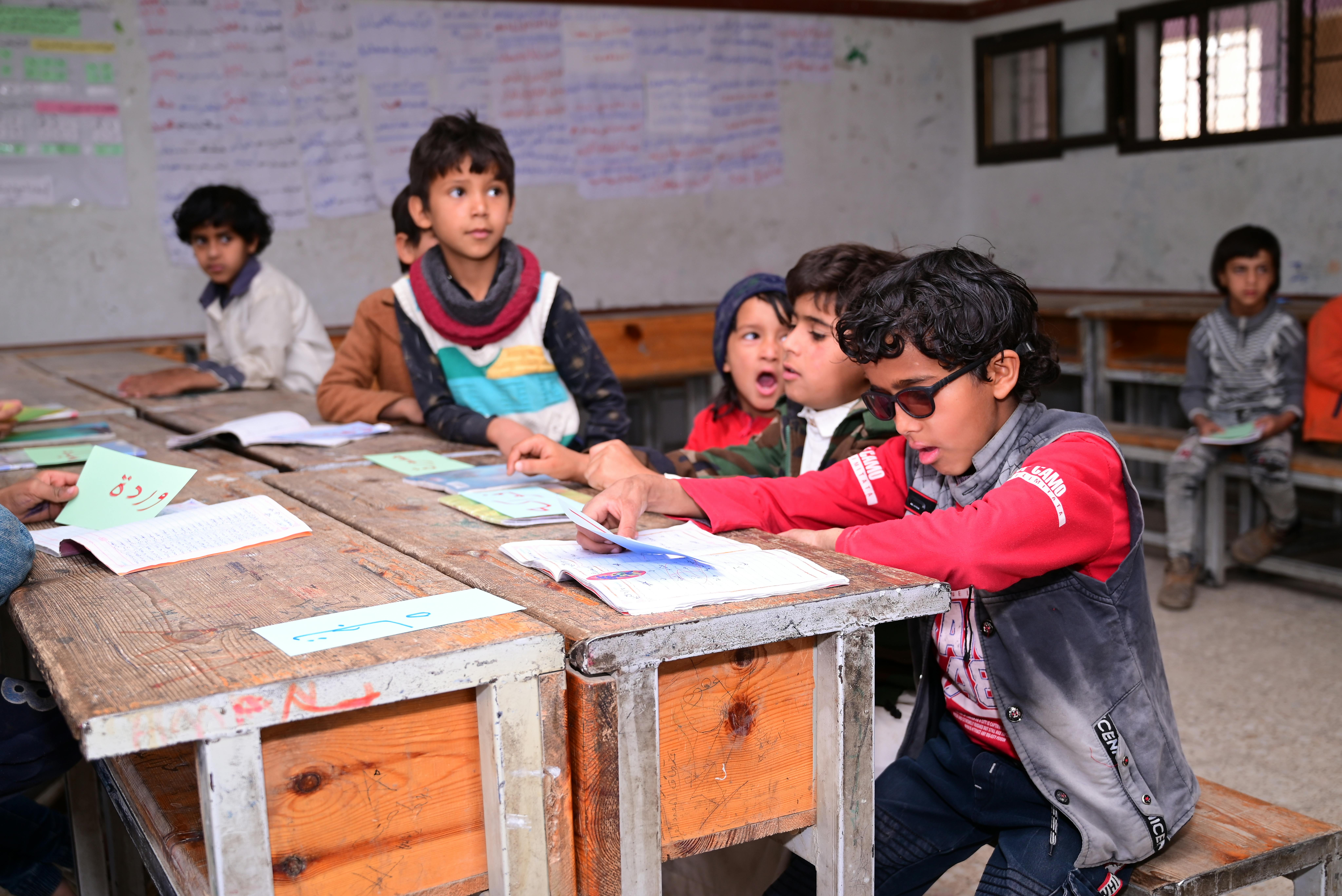 Rakan Al Qadhi è seduto al banco, vicino ai compagni di classe, durante una lezione nella scuola di Al Gardai, Sana’a in Yemen.