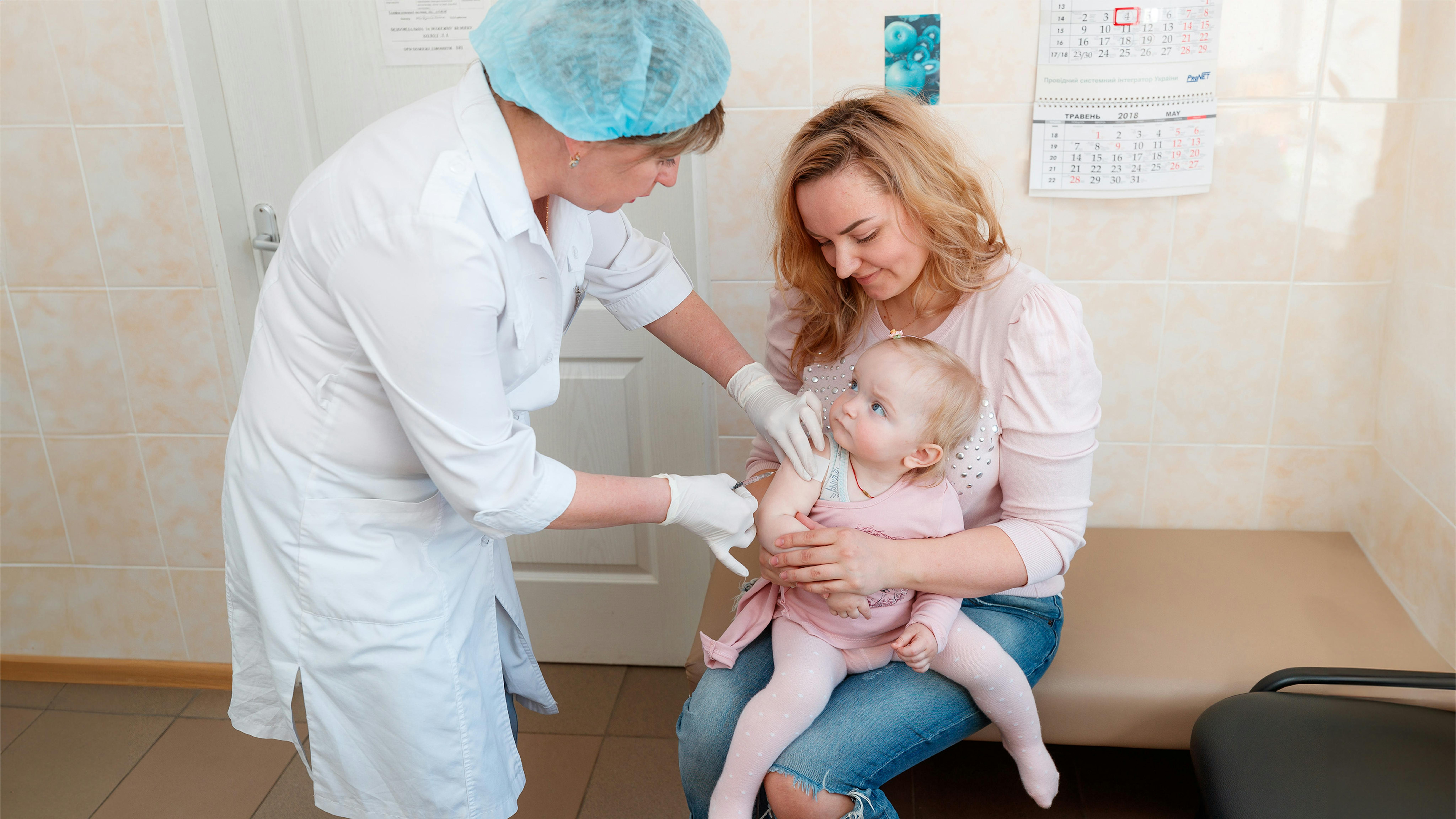 Ucraina - Dana, tenuta dalla madre Inna, non piange mentre le viene somministrata la prima dose di vaccino contro parotite, morbillo e rosolia (MMR)