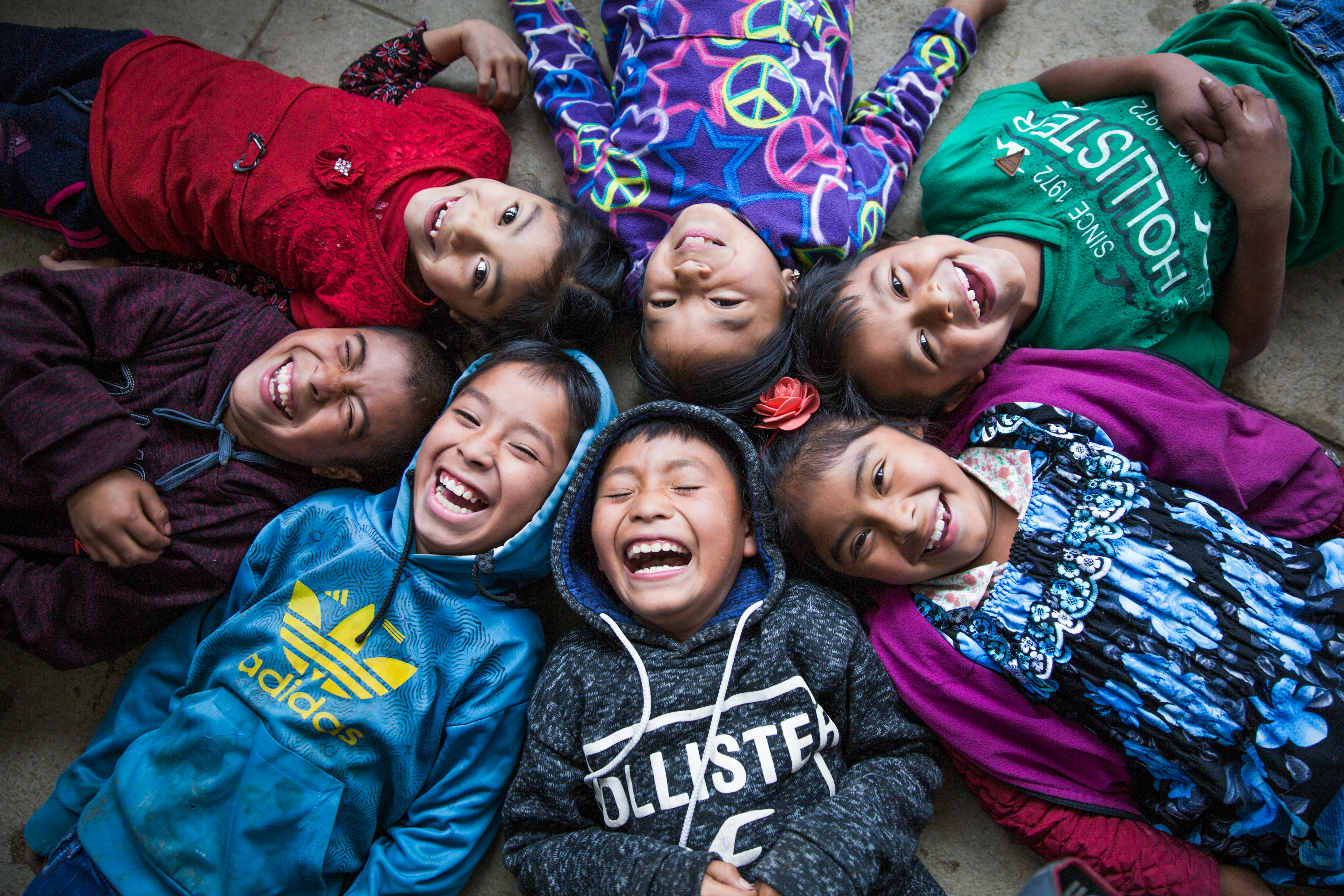 Bambini sdraiati a terra sorridono per il loro ultimo giorno di scuola: fanno parte della comunità indigena di Chicoy di Todos Santos Cuchumatánin, nella provincia di Huehuetenango, Guatemala