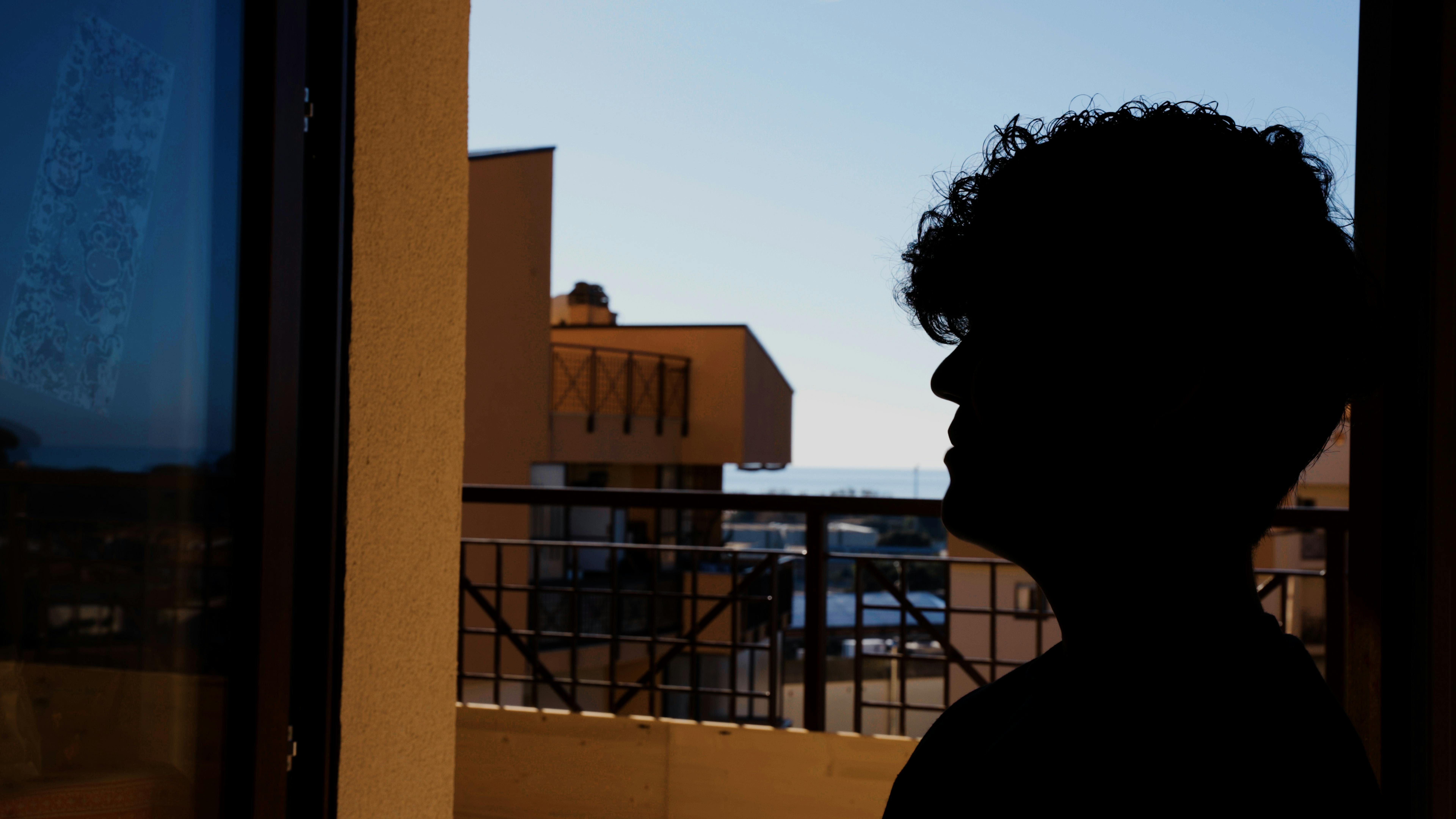 Una storia di affido familiare: M., alla finestra della sua nuova casa di Anzio. Credits foto: UNICEF/Anicito/2023