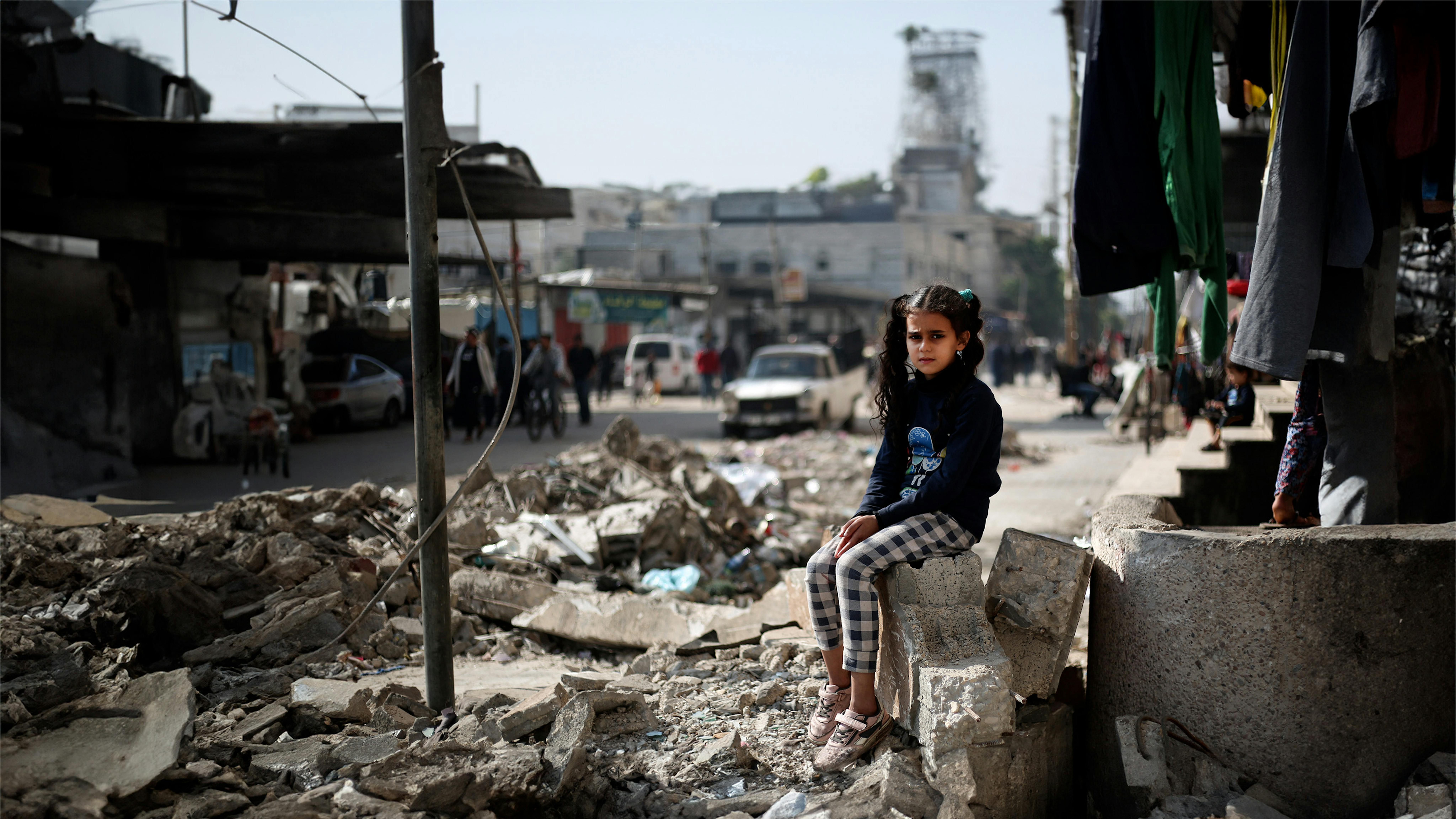 Maha, una bambina di 11 anni, è seduta sulle macerie di una casa a Rafah, nel sud della Striscia di Gaza.