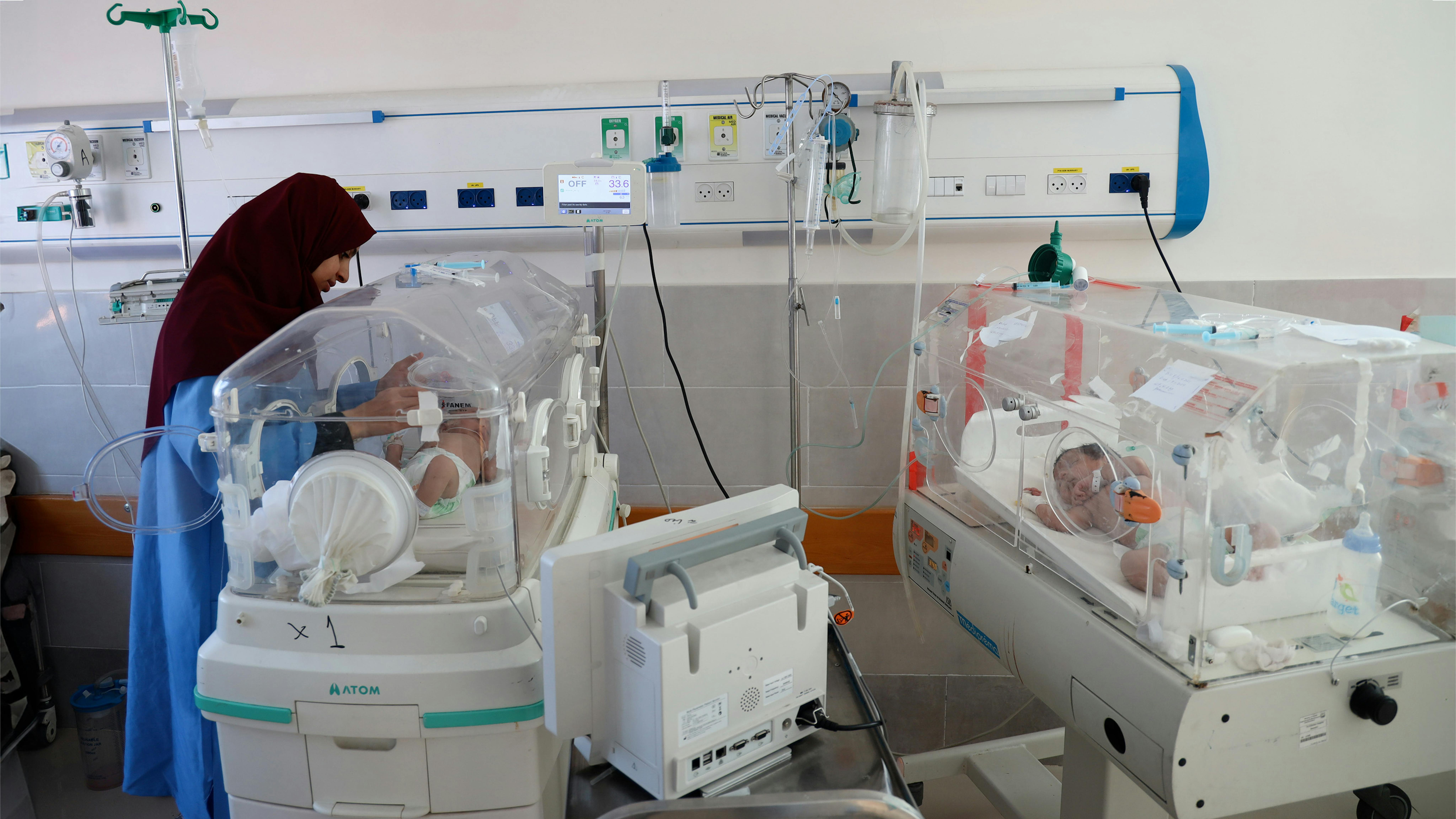 Stato di Palestina, un'infermiera controlla un neonato che giace all'interno di un'incubatrice presso l'ospedale di maternità degli Emirati a Rafah