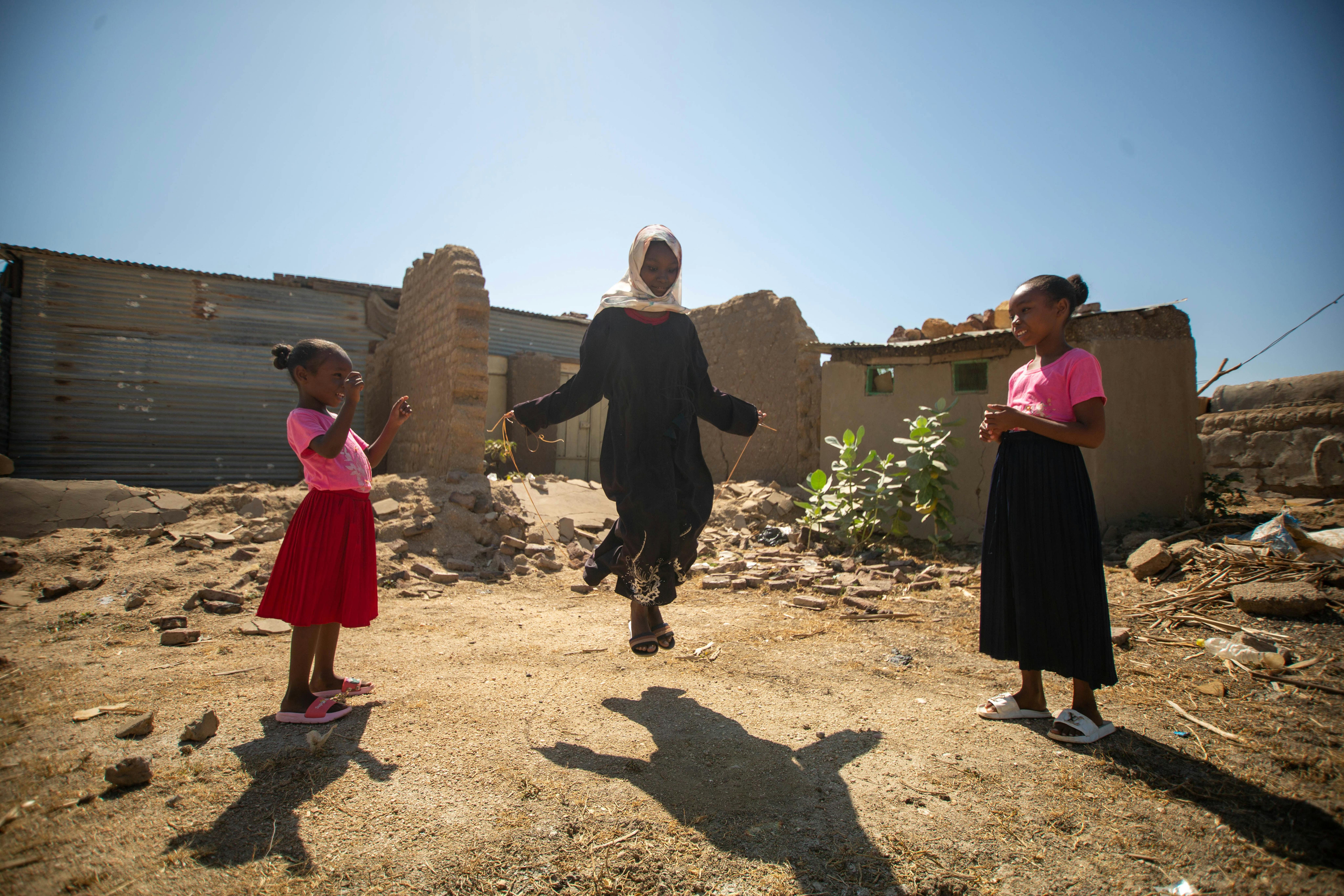 Fiyha gioca con le sue sorella fuori casa, nella remota località di Al-Gabaleen, nello stato del Nilo Bianco, in Sudan.