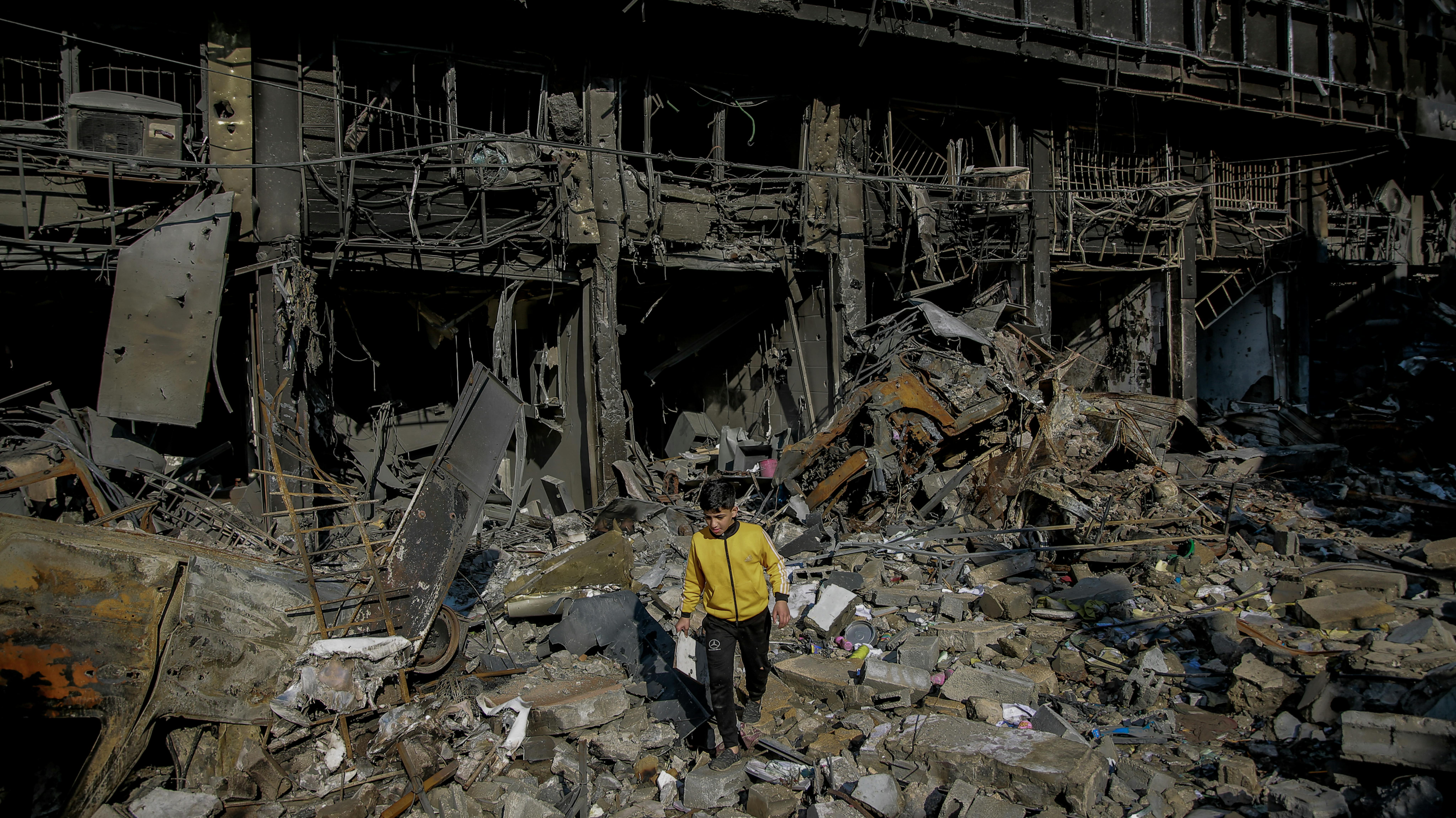 Ali, un bambino di 11 anni cammina sulle macerie della sua casa distrutta in via Omar Al-Mukhtar a Gaza City