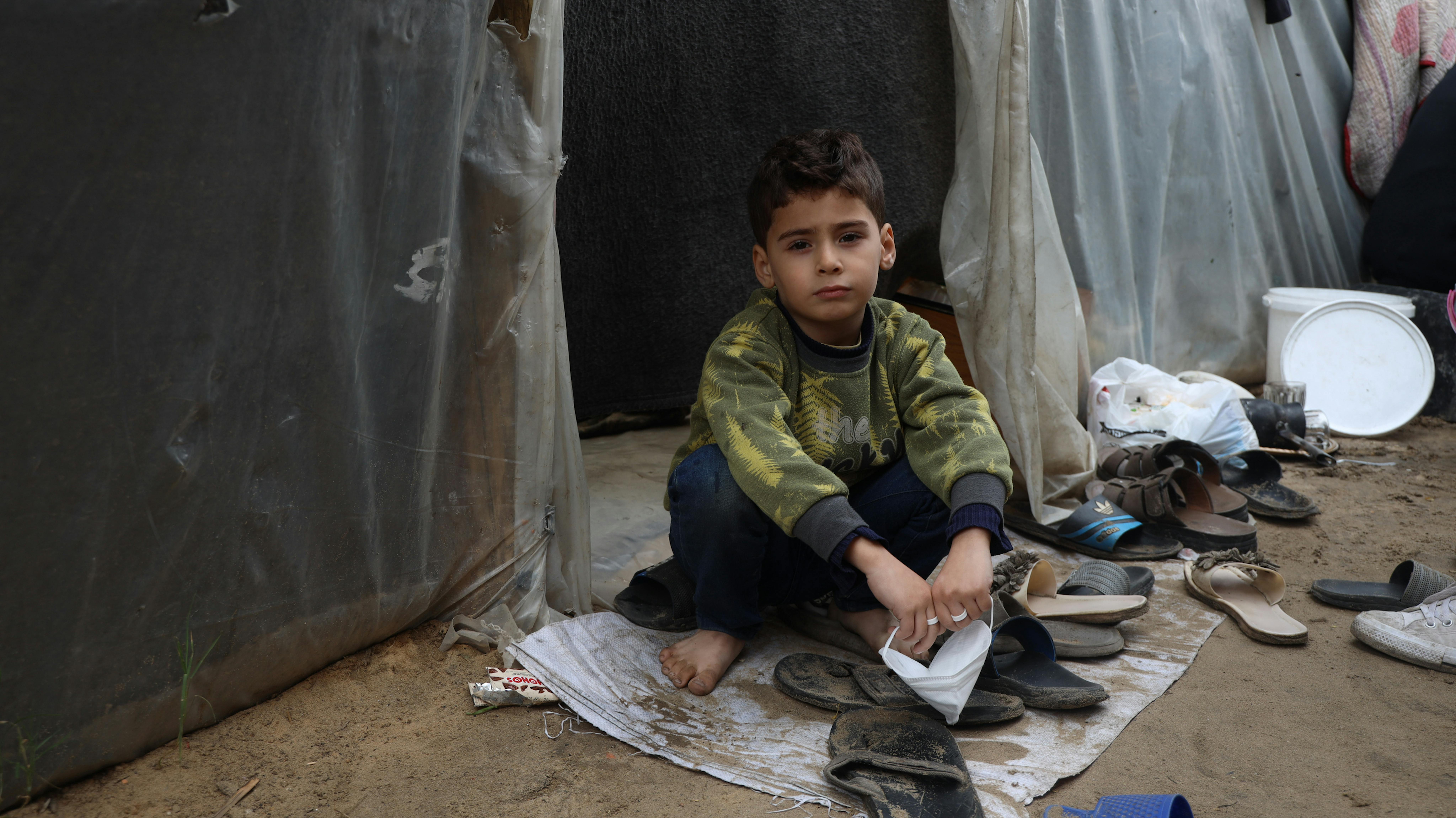 Un bambino in una tenda in un centro di accoglienza situato all'interno dell'Università di Al-Aqsa nella Striscia di Gaza