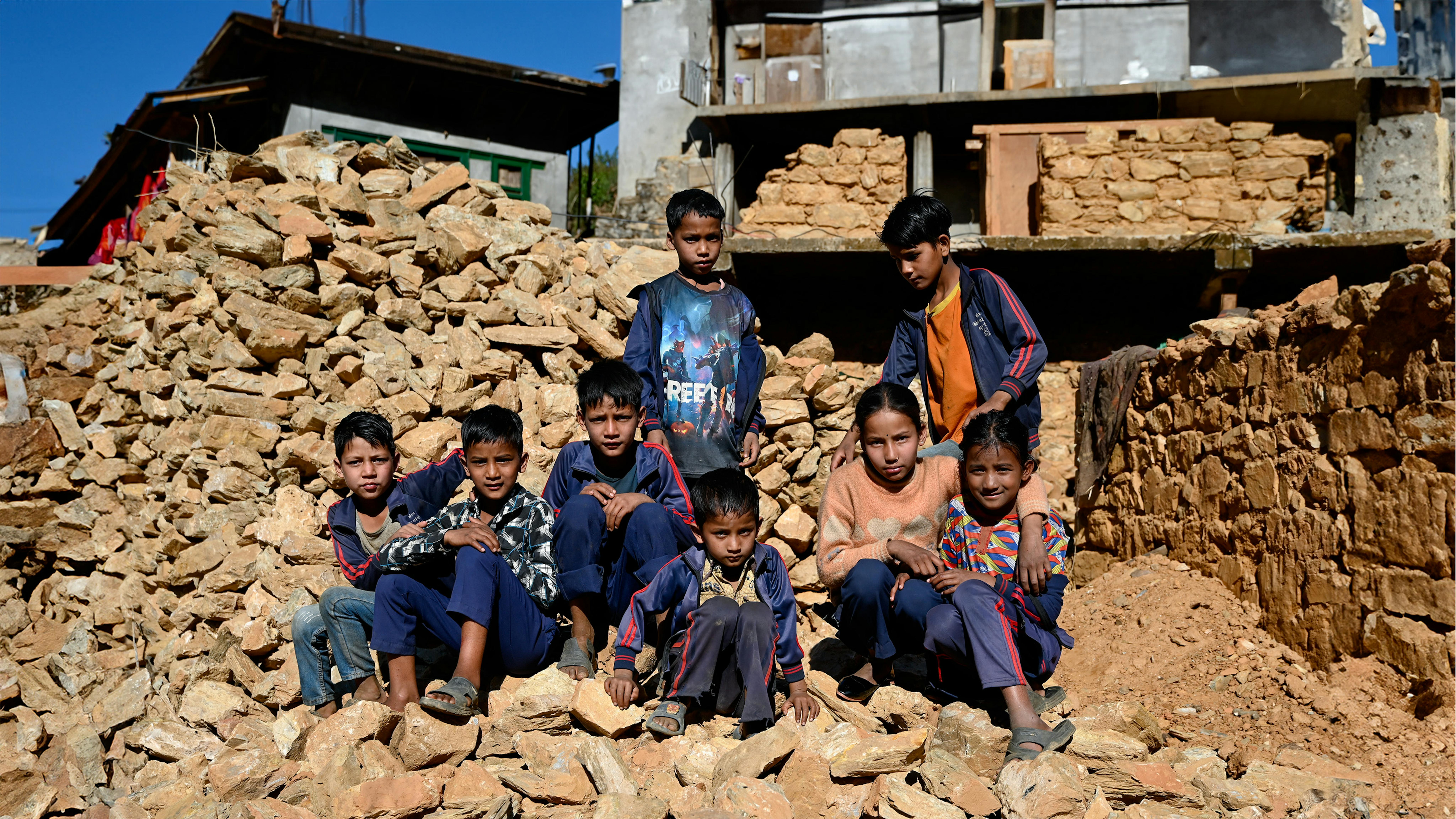 nella municipalità rurale di Sani Bheri, nel distretto occidentale di Rukum, nel Nepal occidentale, gli studenti della scuola secondaria superiore Shree Saraswati osservano la costruzione di un centro di apprendimento transitorio nei locali con il sostegno dell'UNICEF.