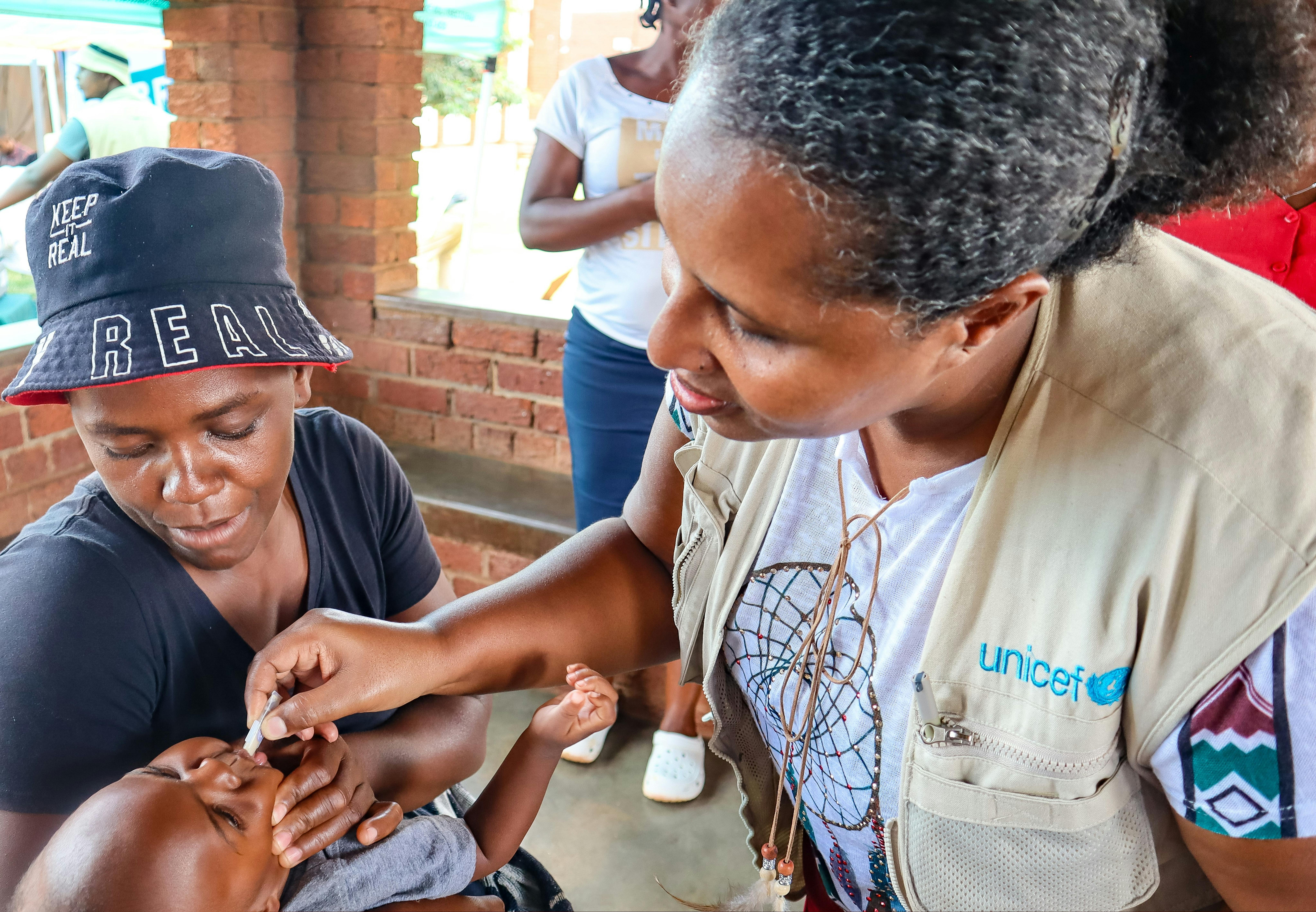 Un'operatrice UNICEF somministra il vaccino contro il colera ad un bambino, tenuto in braccio dalla mamma. Siamo in Zimbabwe, uno dei 13 paesi colpiti dalle più grande epidemia di colera degli ultimi anni