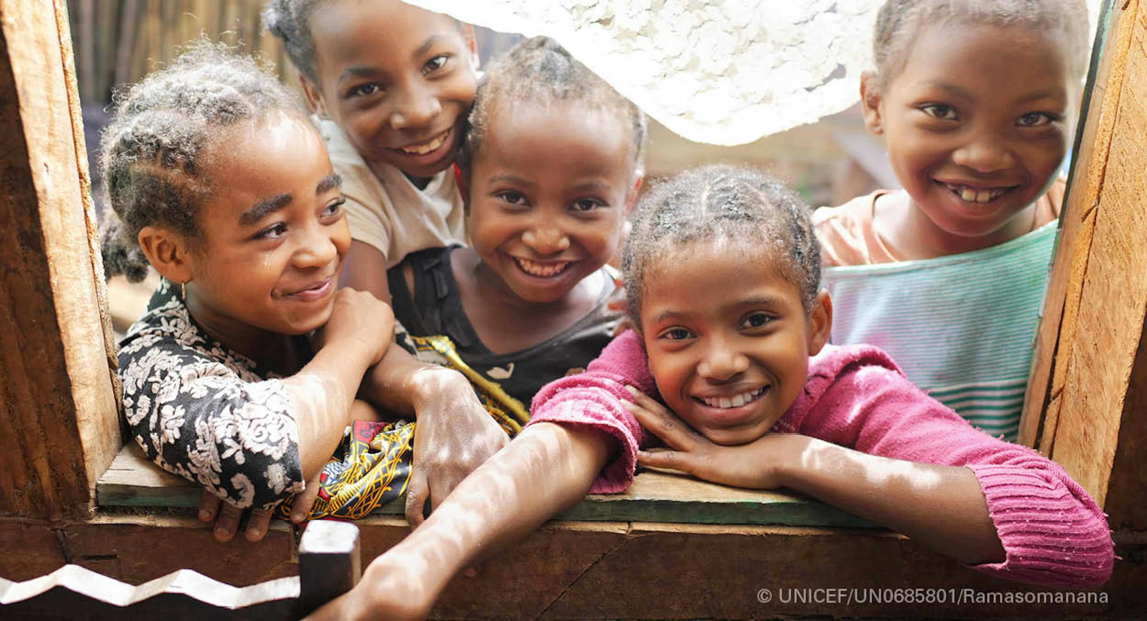 Madagascar , bambini sorridenti che guardano attraverso la finestra del Centro nutrizionale di Tsaramainandro