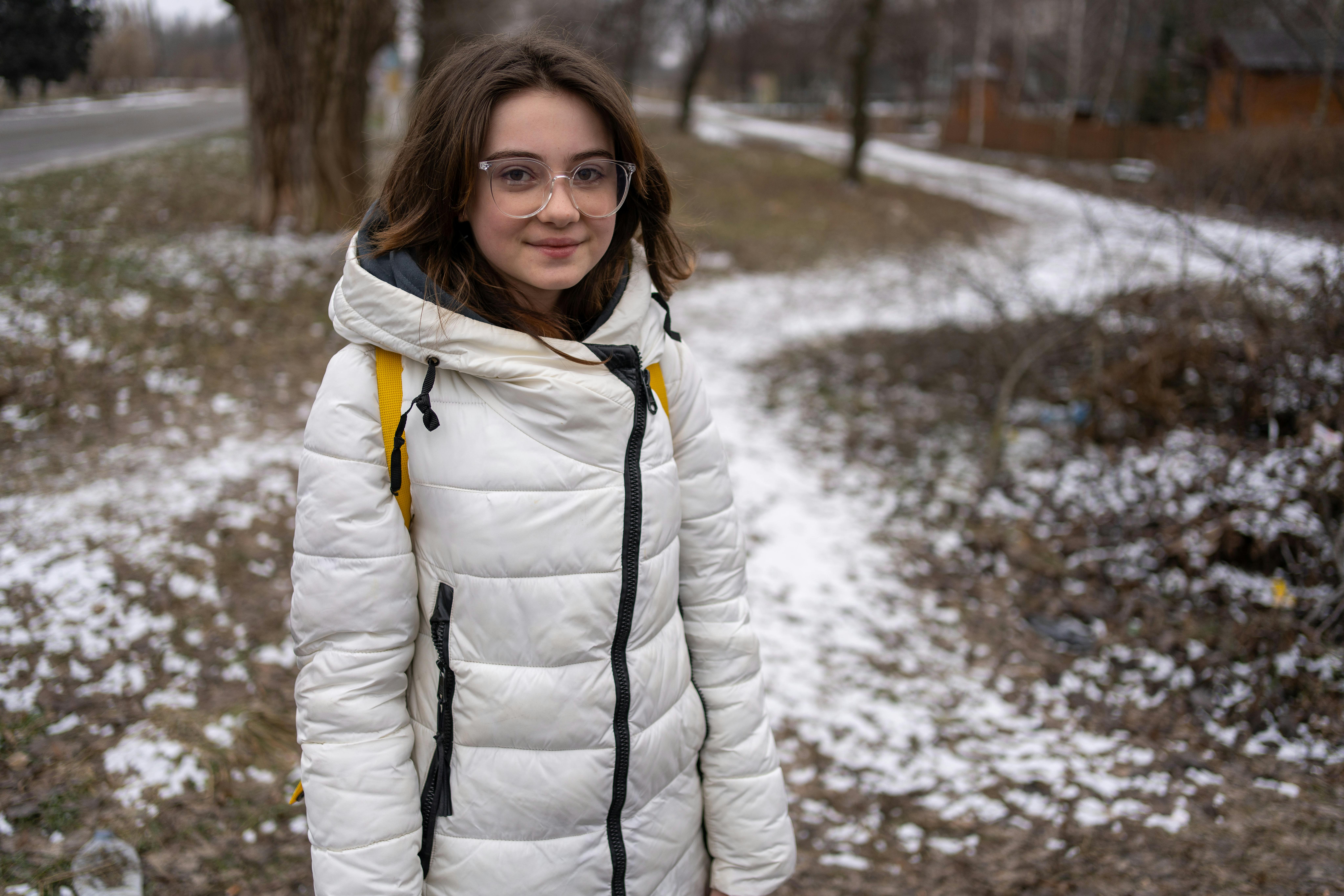 Alyona, 13 anni, mentre aspetta l'autobus per l'evacuazione dalla zona di Kurakhove, in Ucraina, dove da inizio anno i bombardamenti sono sempre più intensi